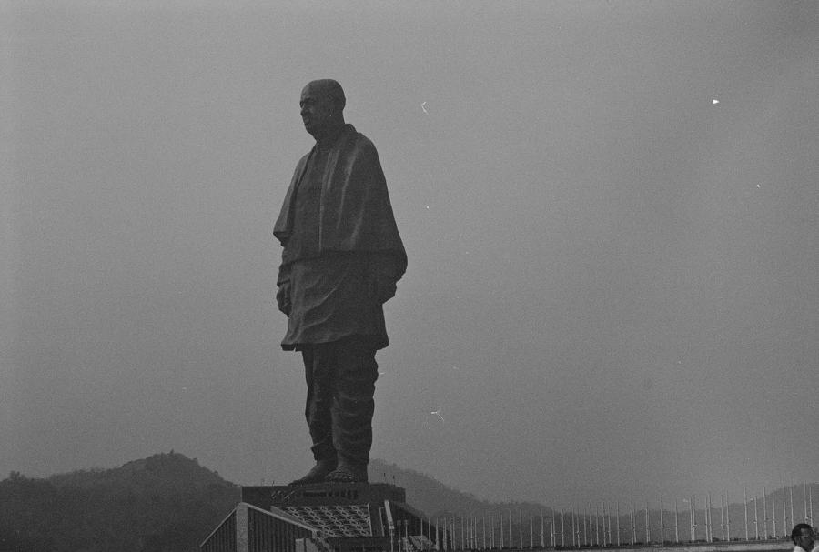 The Statue of Unity, the 182-metre bronze statue of Sardar Vallabhbhai Patel in Gujarat, photographed in silhouette against a hazy sky
