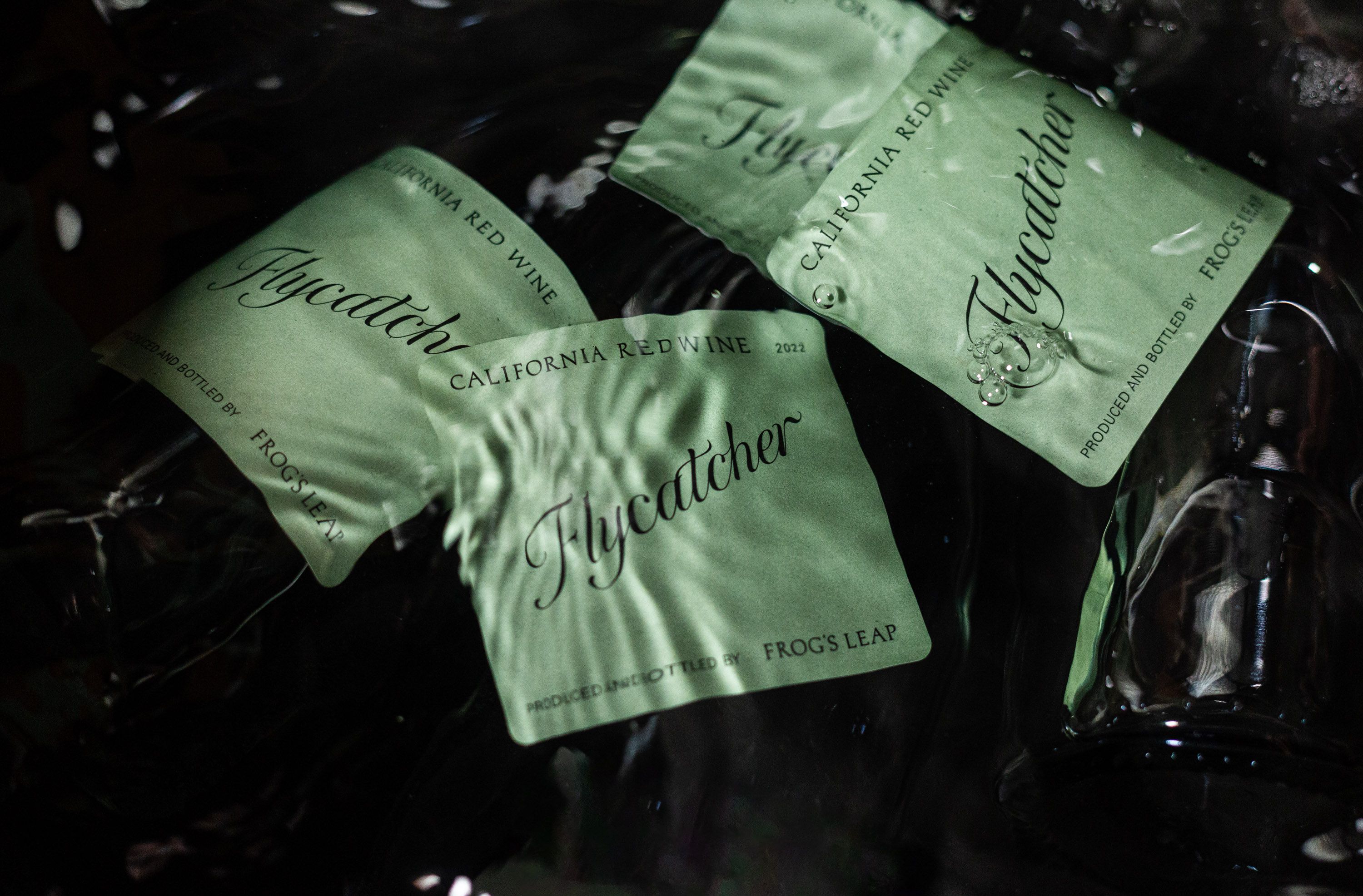 Image of Flycatcher wine labels submerged in water. 