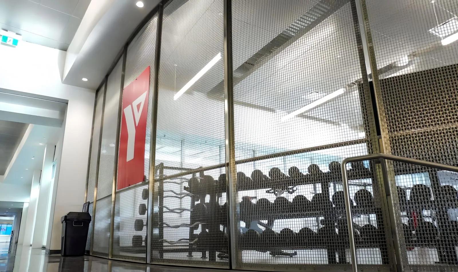 Interior metal mesh partition dividing a commercial fit-out while keeping light and visibility