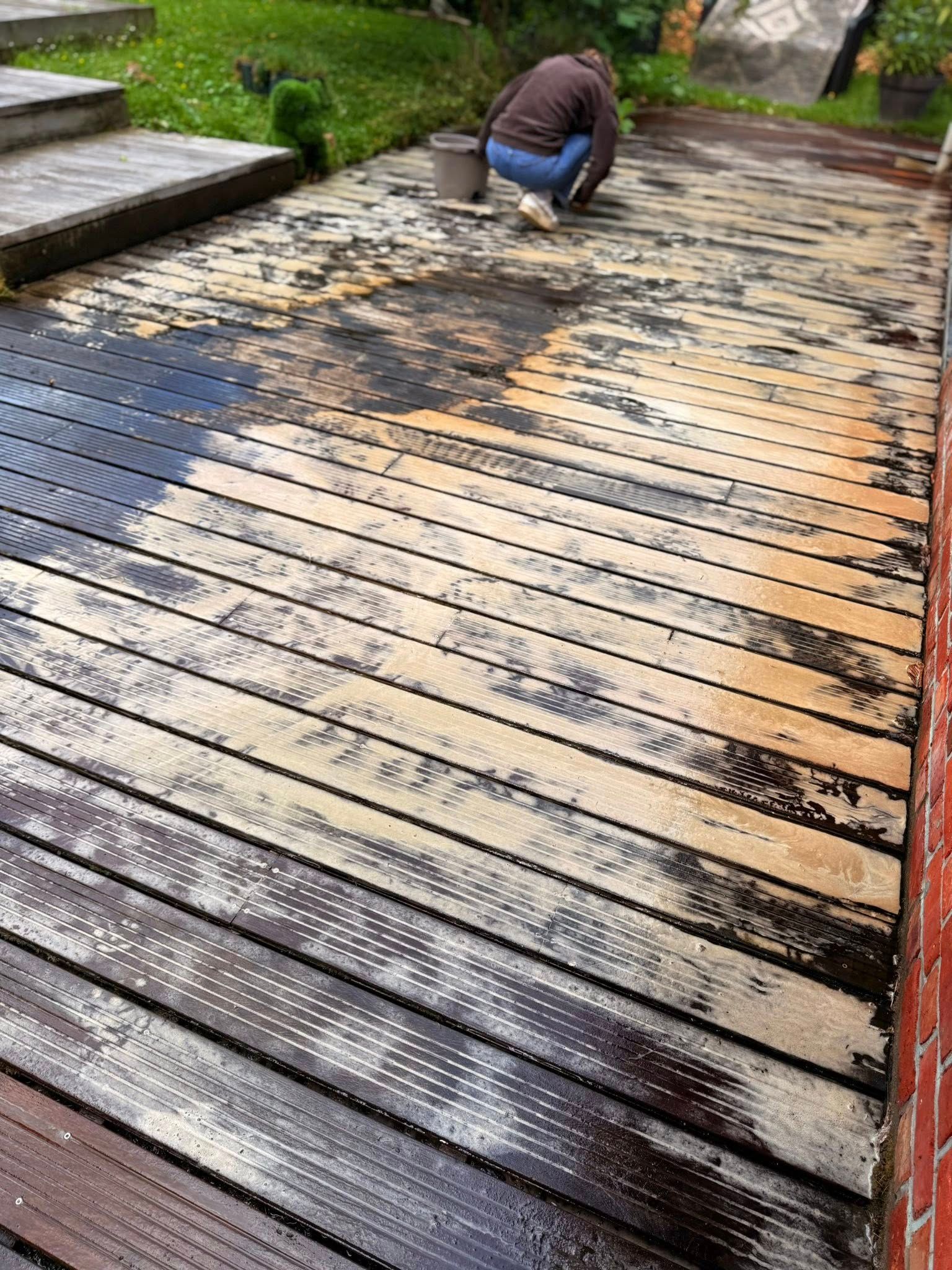 Terrasse en lames de bois encrassée par la mousse et le biofilm vert à Mérignies avant nettoyage