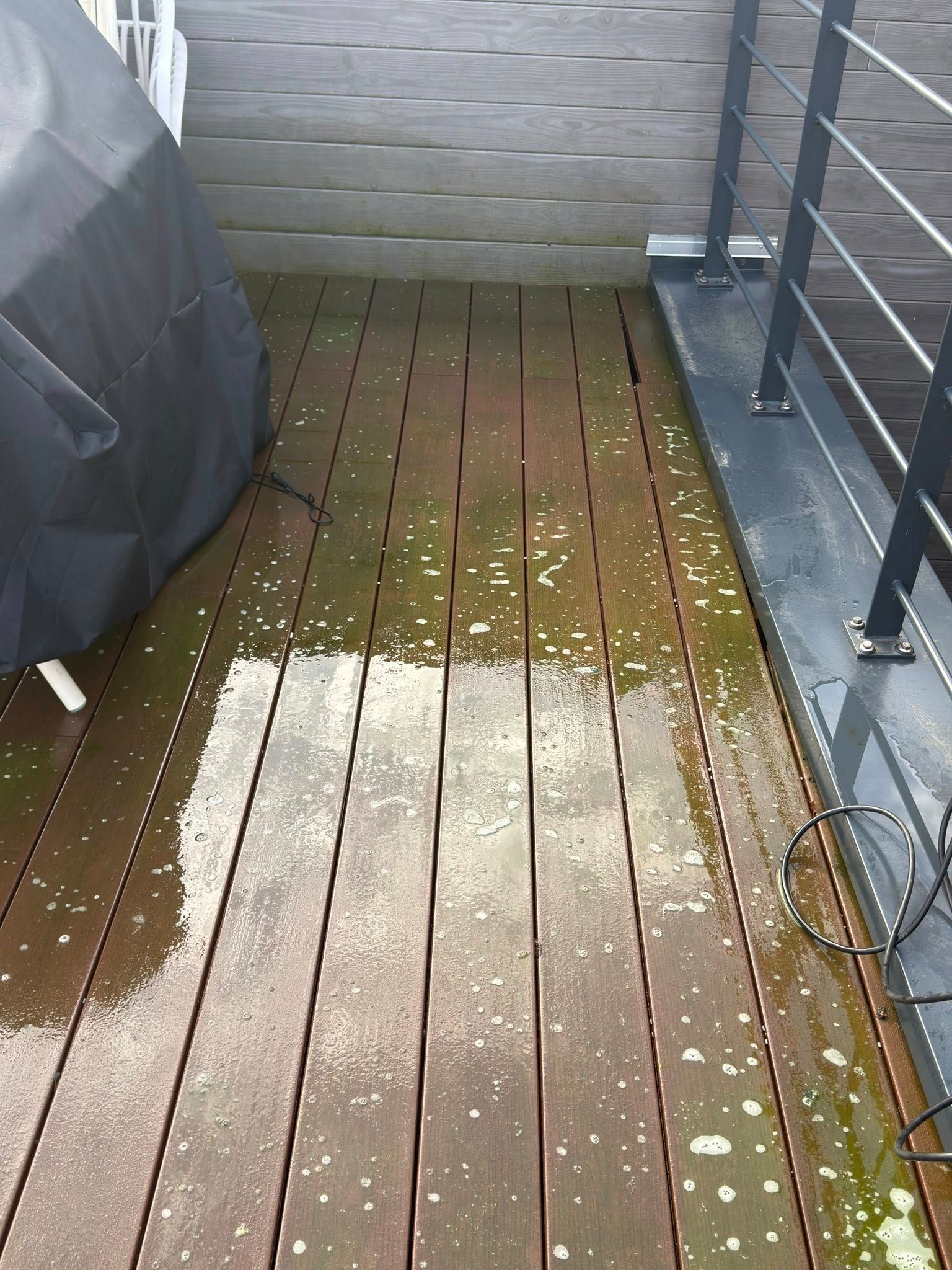 Terrasse en résine grise encrassée par la pollution et les mousses à Lille avant intervention