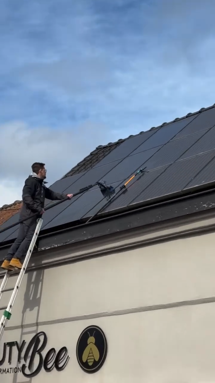 Laveur professionnel nettoyant des panneaux photovoltaïques à la brosse souple à Templeuve