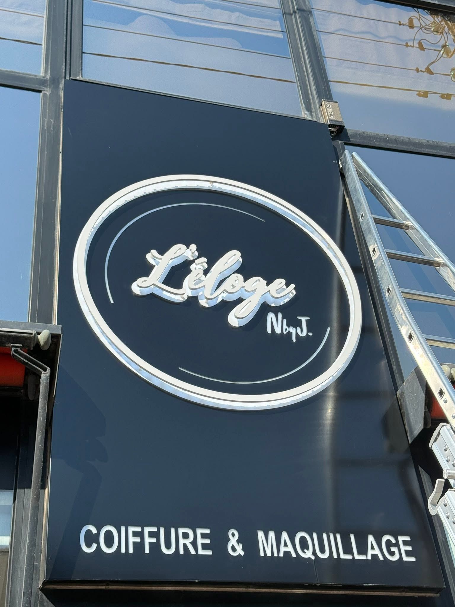 PAANDAWLV nettoyant le bandeau d'une enseigne commerciale en hauteur à Lys-lez-Lannoy