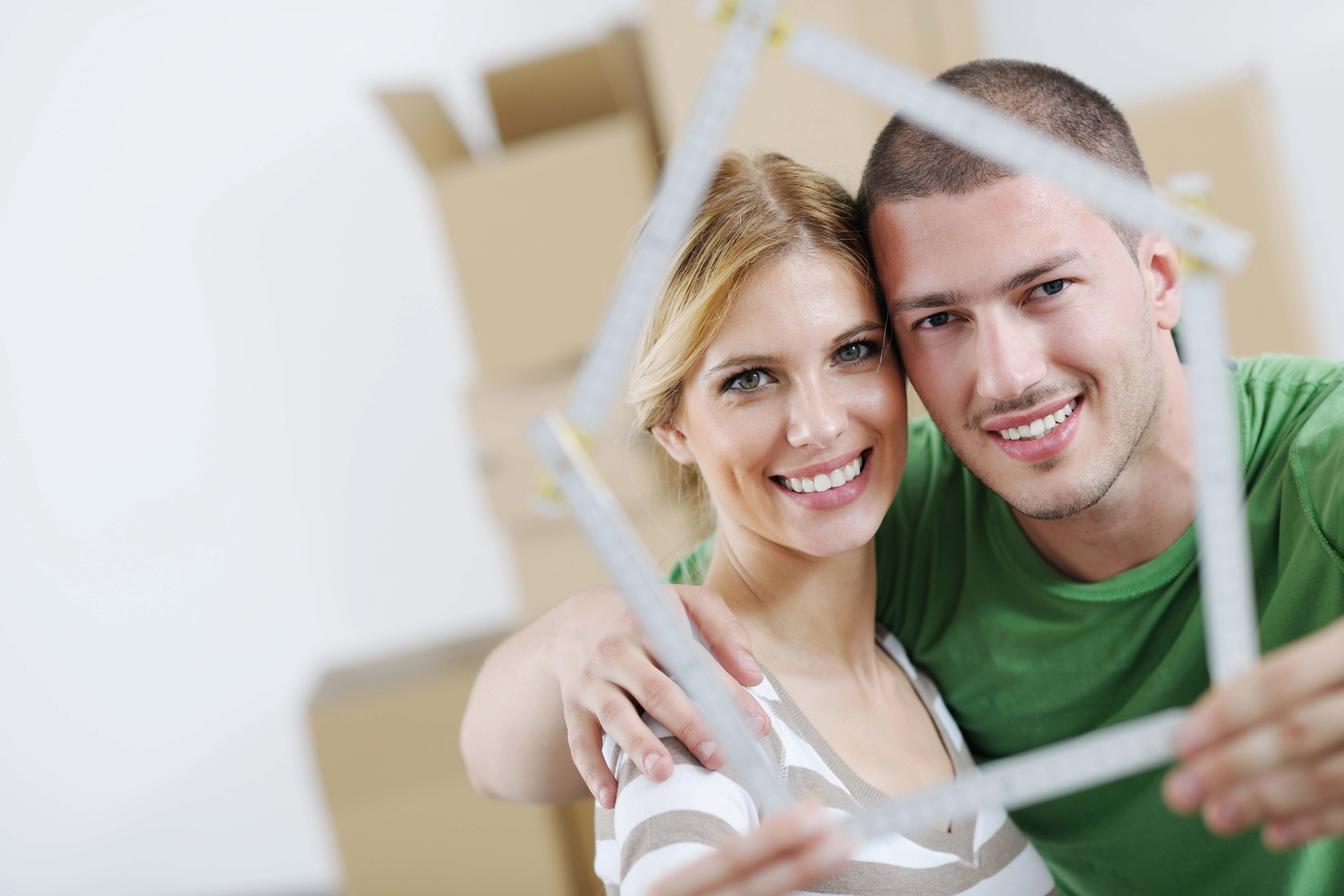 First time home buyers holding miniature house structure.