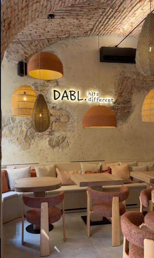 Neonový nápis Dabl. hits different nad lavicí