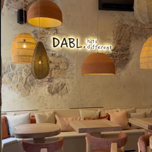 Neonový nápis Dabl. hits different nad lavicí