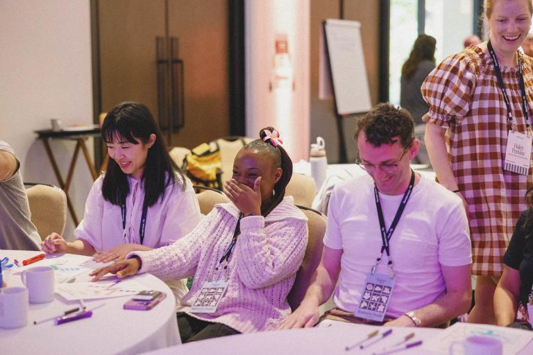 colleagues laughing together at a workshop table