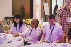 colleagues laughing together at a workshop table