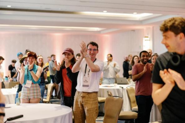employees standing and clapping at an event