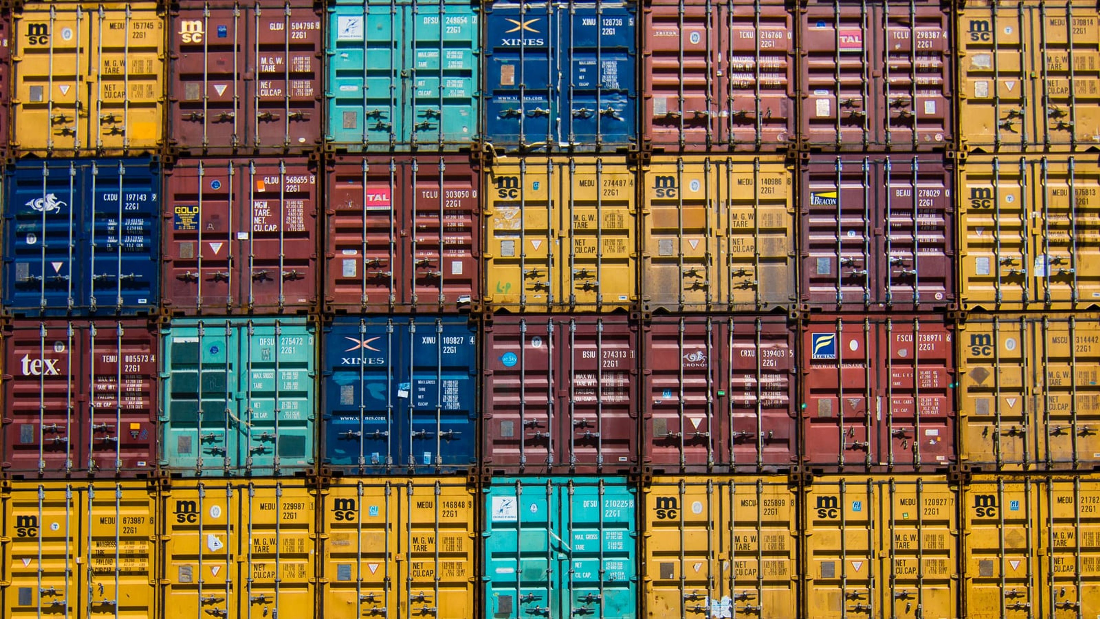 Rows of stacked shipping containers in a depot, the inventory a buyer or renter chooses from