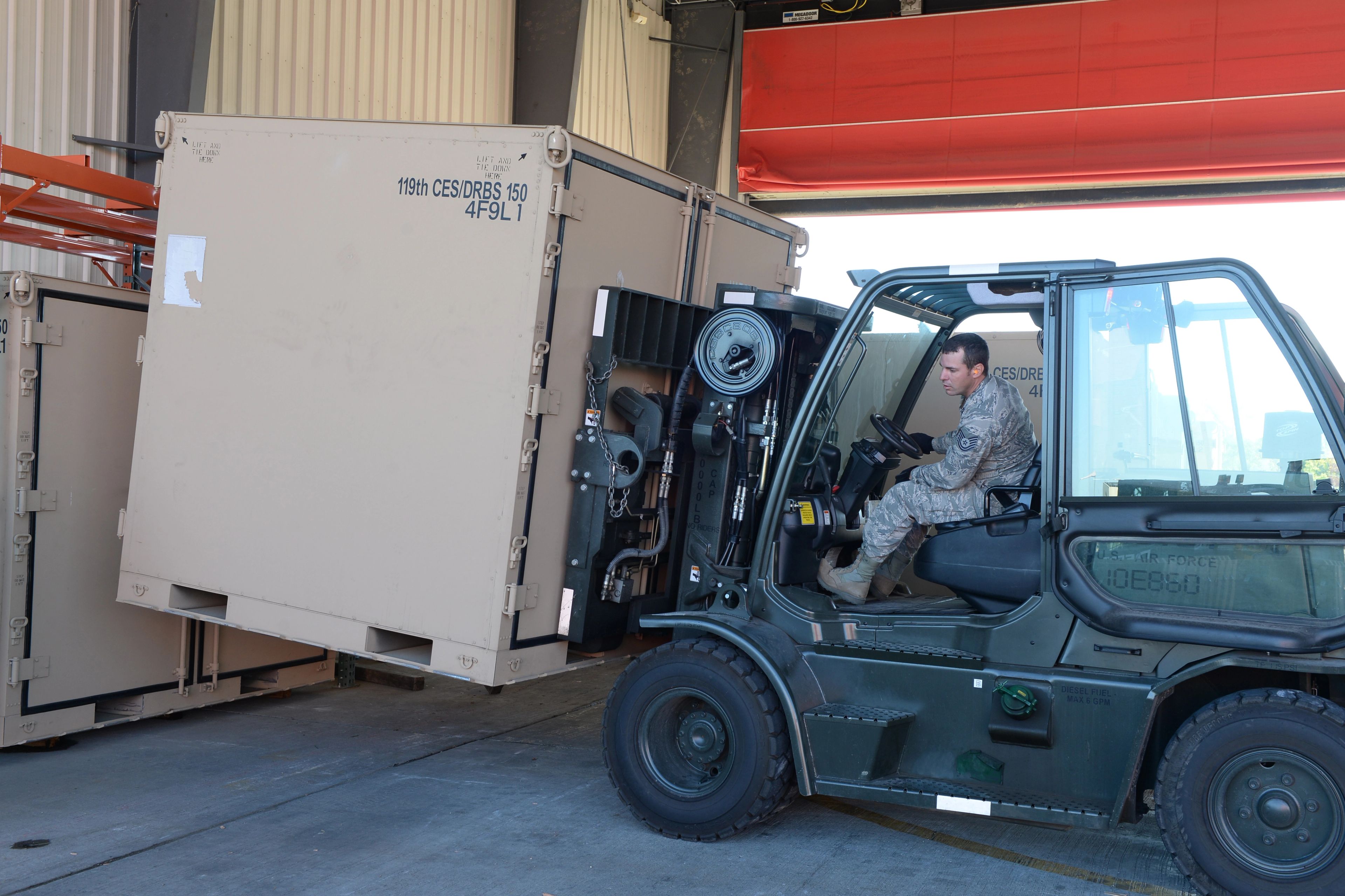 Forklift loading a heavy pallet into a shipping container