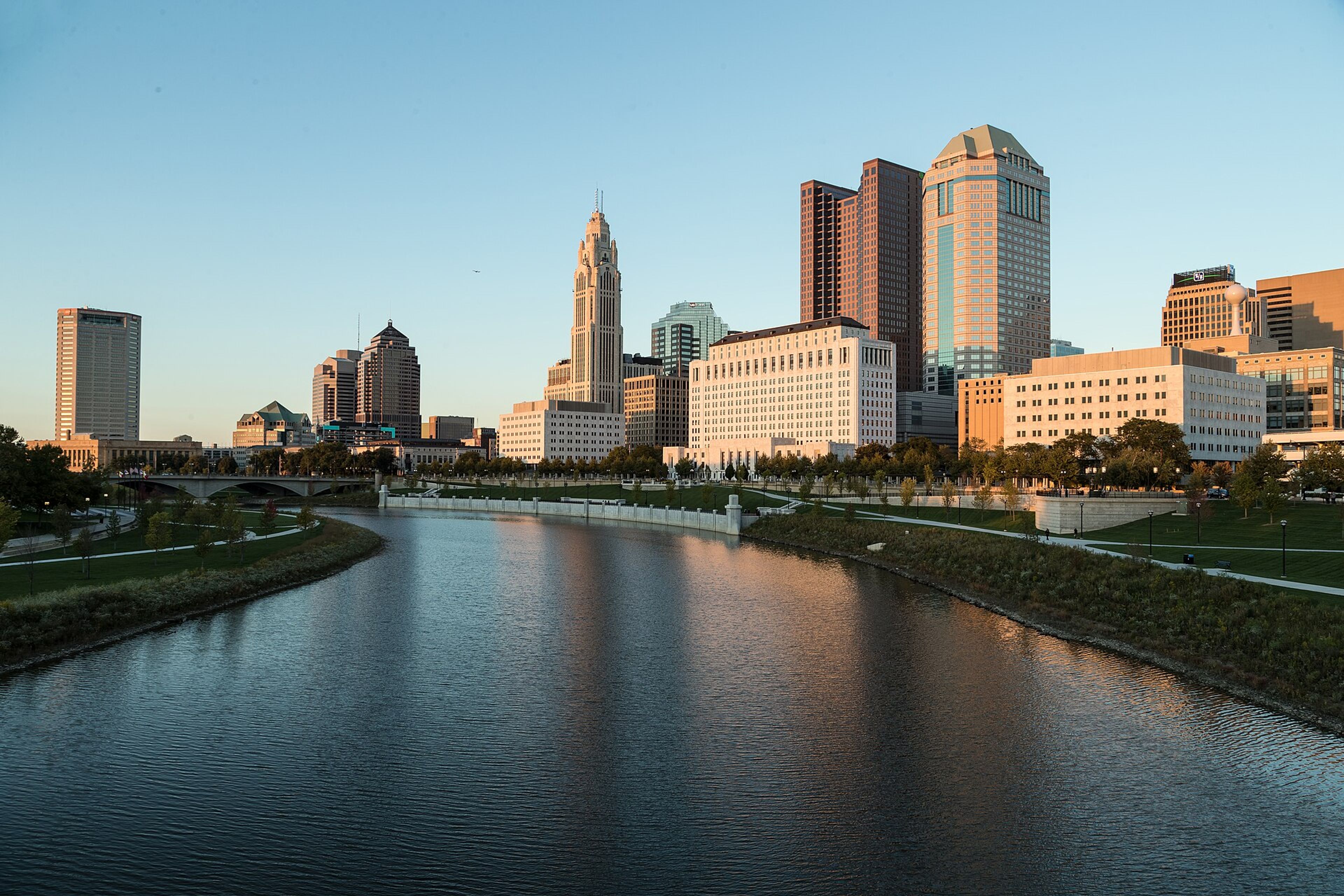 Columbus, Ohio skyline and the Scioto River at sunset, with park paths along both banks