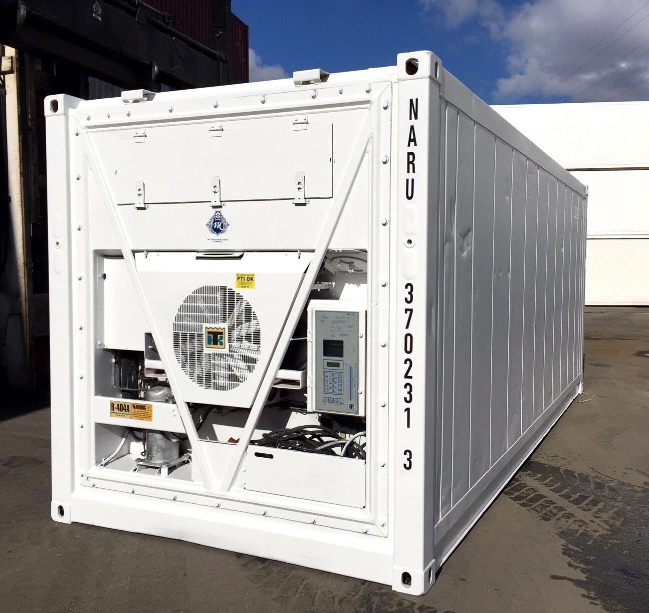 A white reefer container with its machinery end exposed, showing the condenser fan, compressor and control panel