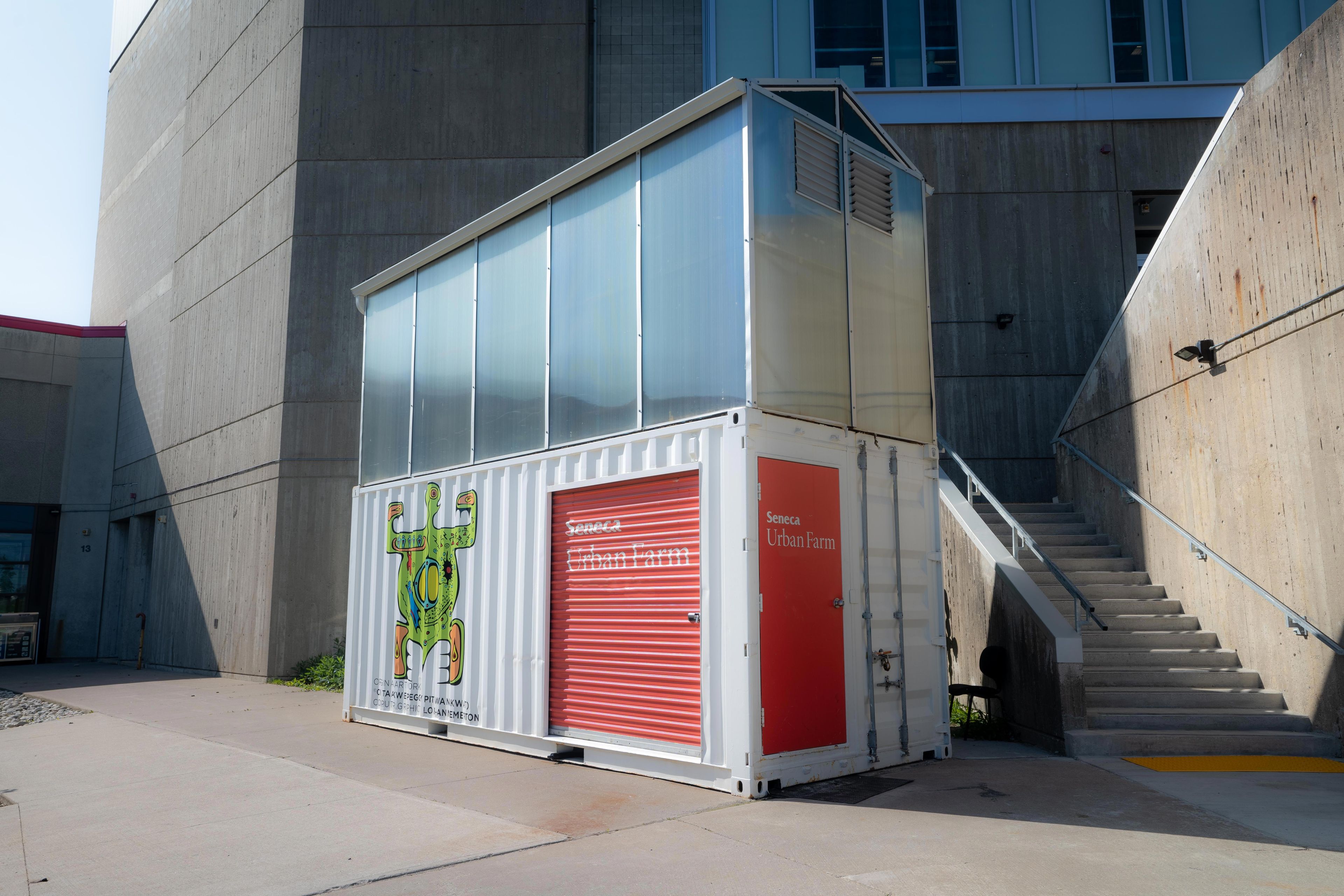 Shipping container converted into an urban farm greenhouse with a glazed upper section