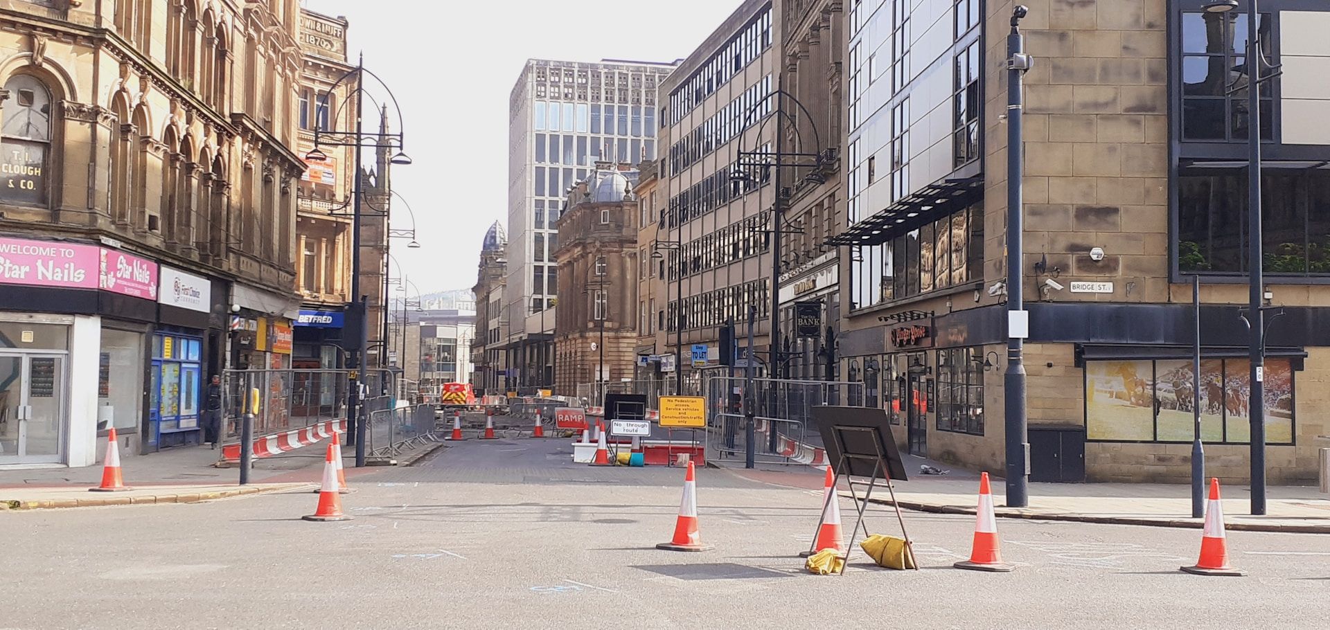Panoramic view of UK road works with cones - merge in turn