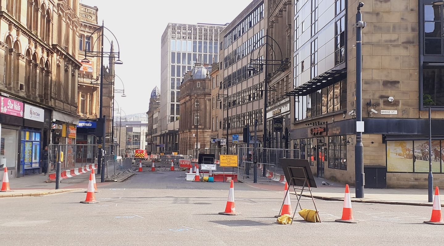 Panoramic view of UK road works with cones - merge in turn