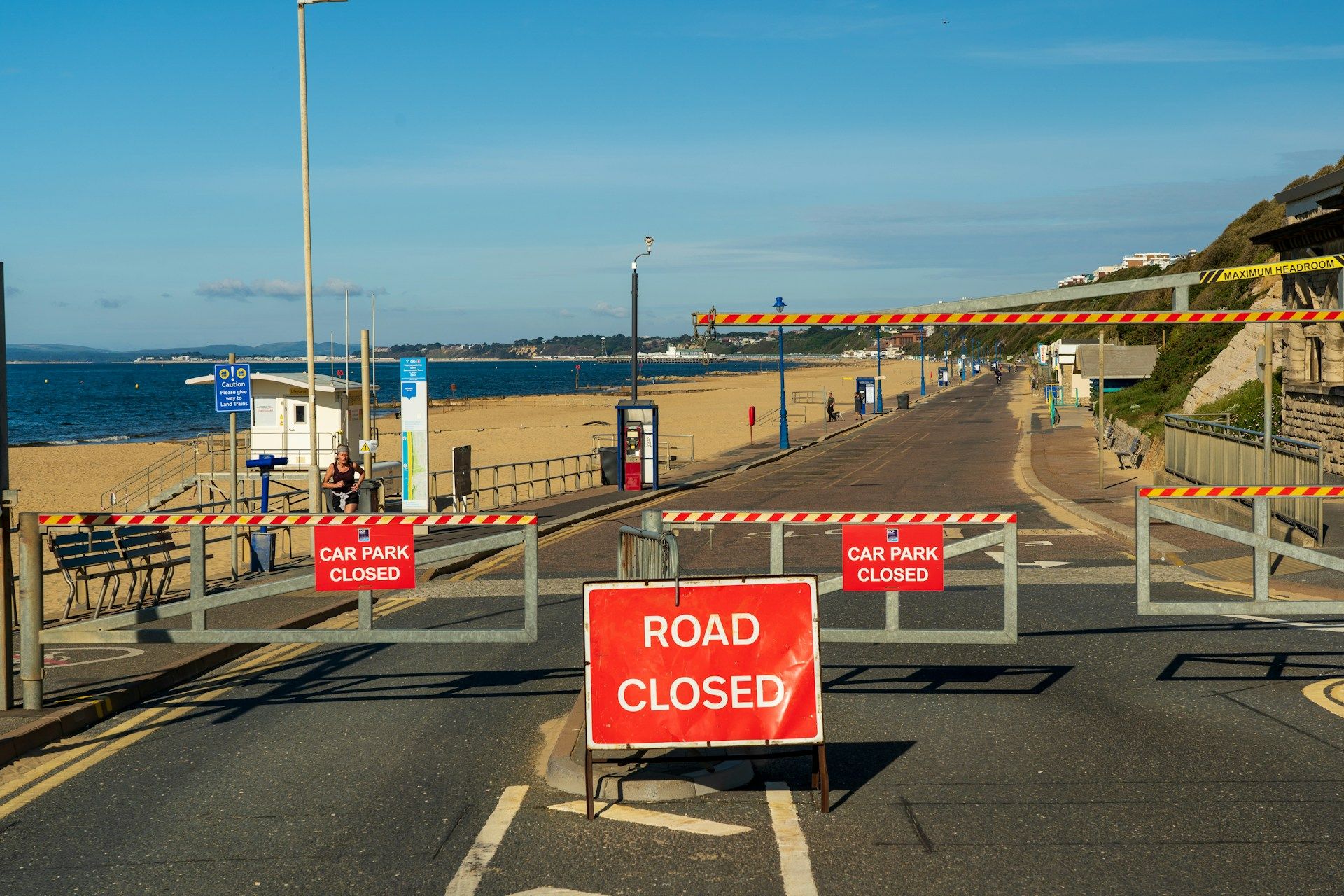 Metal "ROAD CLOSED" and "CAR PARK CLOSED" barriers at a seafront promenade - cycle lanes uk