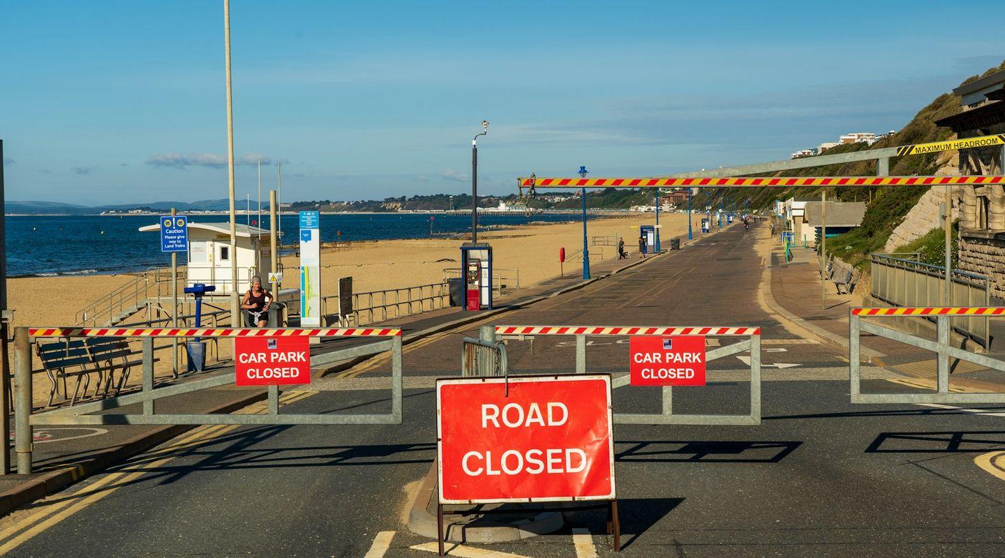Metal "ROAD CLOSED" and "CAR PARK CLOSED" barriers at a seafront promenade - cycle lanes uk