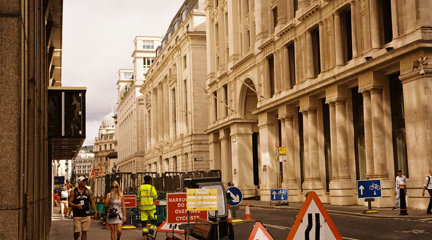 London city street with active road works: men-at-work and road-narrows signs - merge in turn