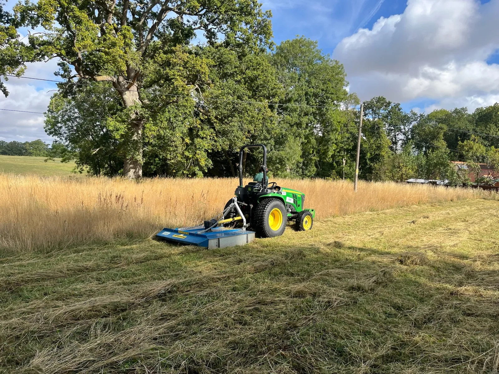 Mowing field with small tractor
