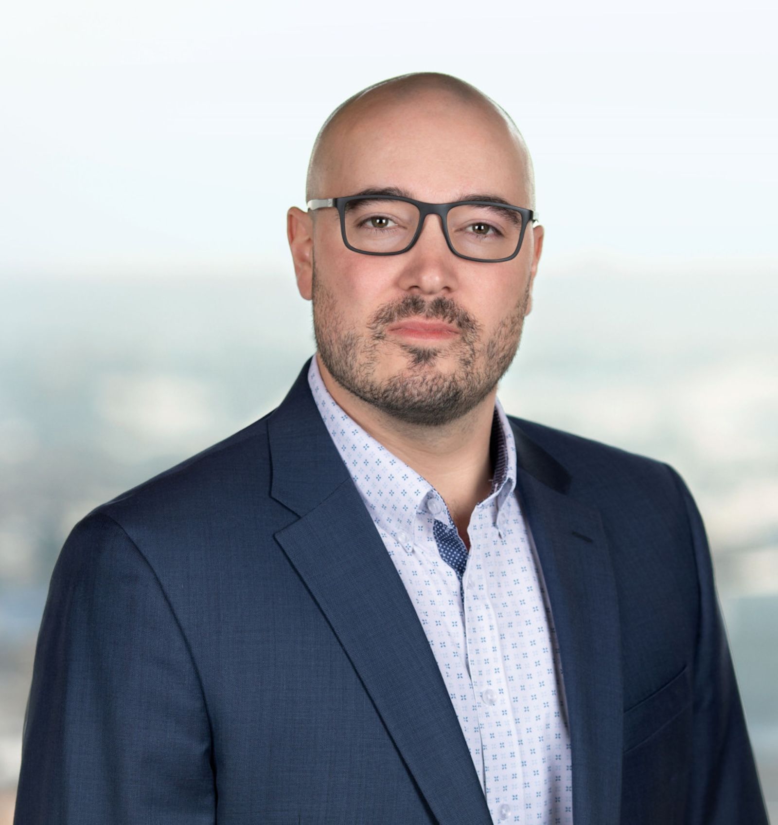 Headshot of Garrett McMullen against a fuzzy landscape backdrop.