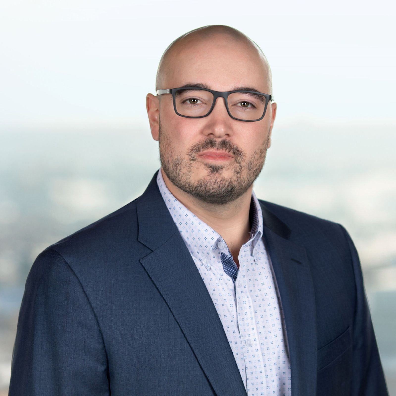 Headshot of Garrett McMullen against a fuzzy landscape backdrop.