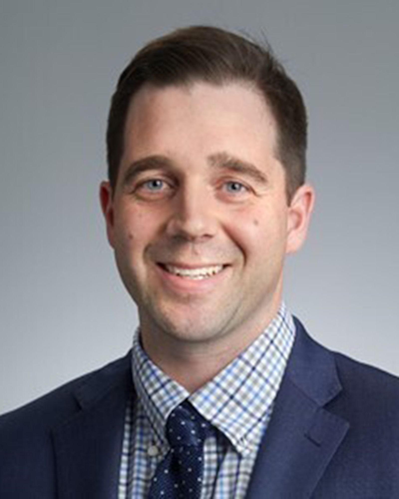 Headshot of Sean Foley on a grey background.