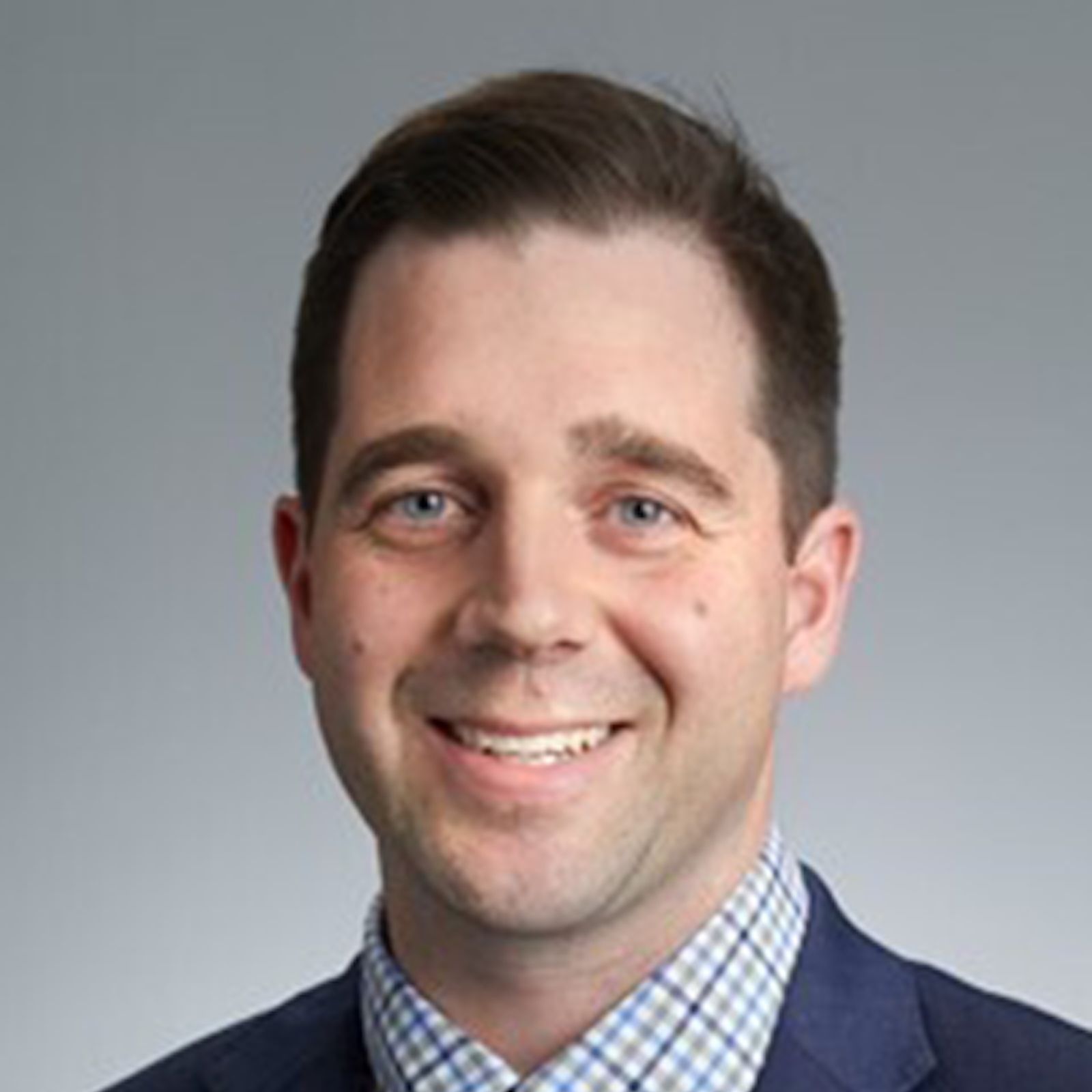 Headshot of Sean Foley on a grey background.