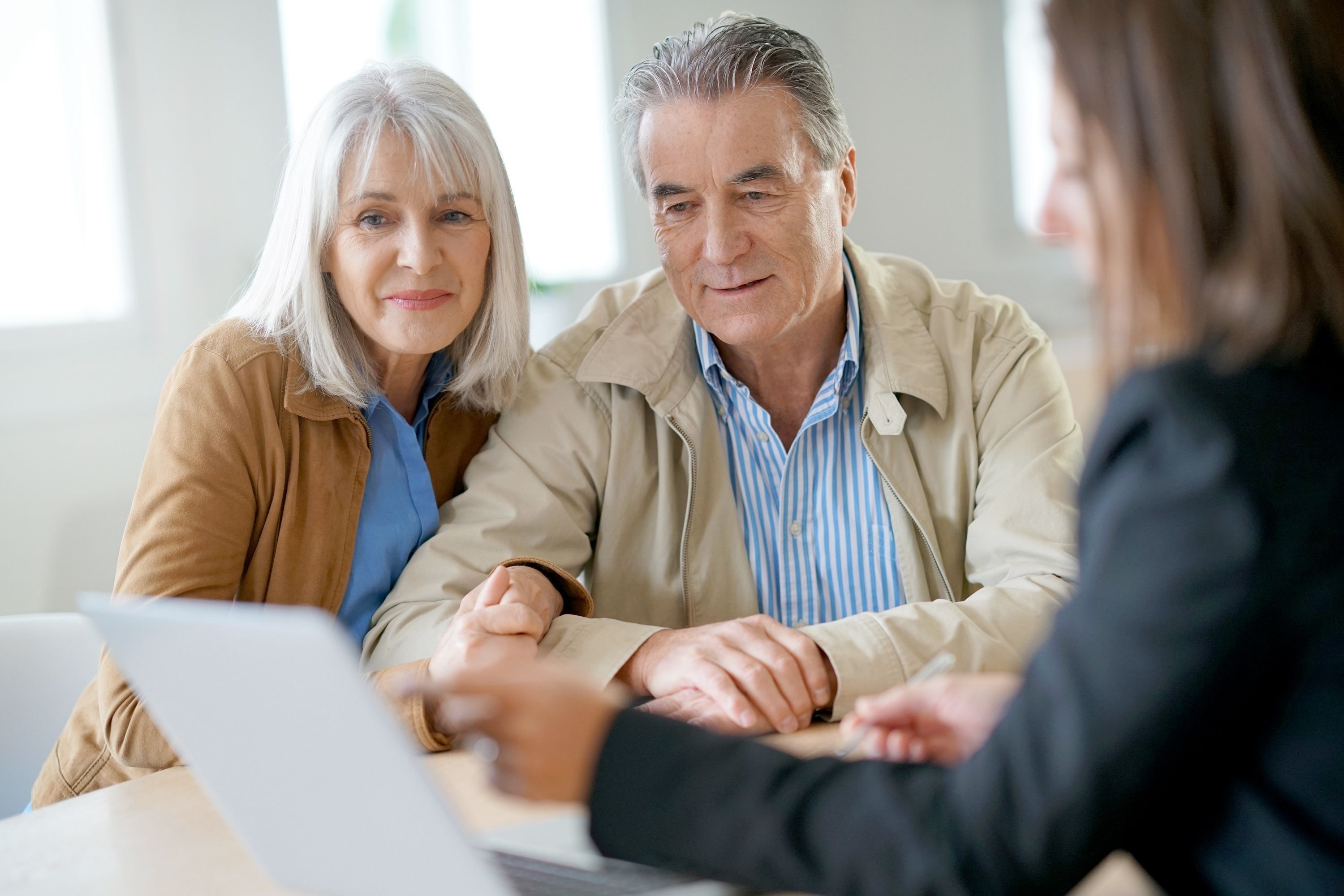 A financial advisor proposes some thoughts to an older couple.