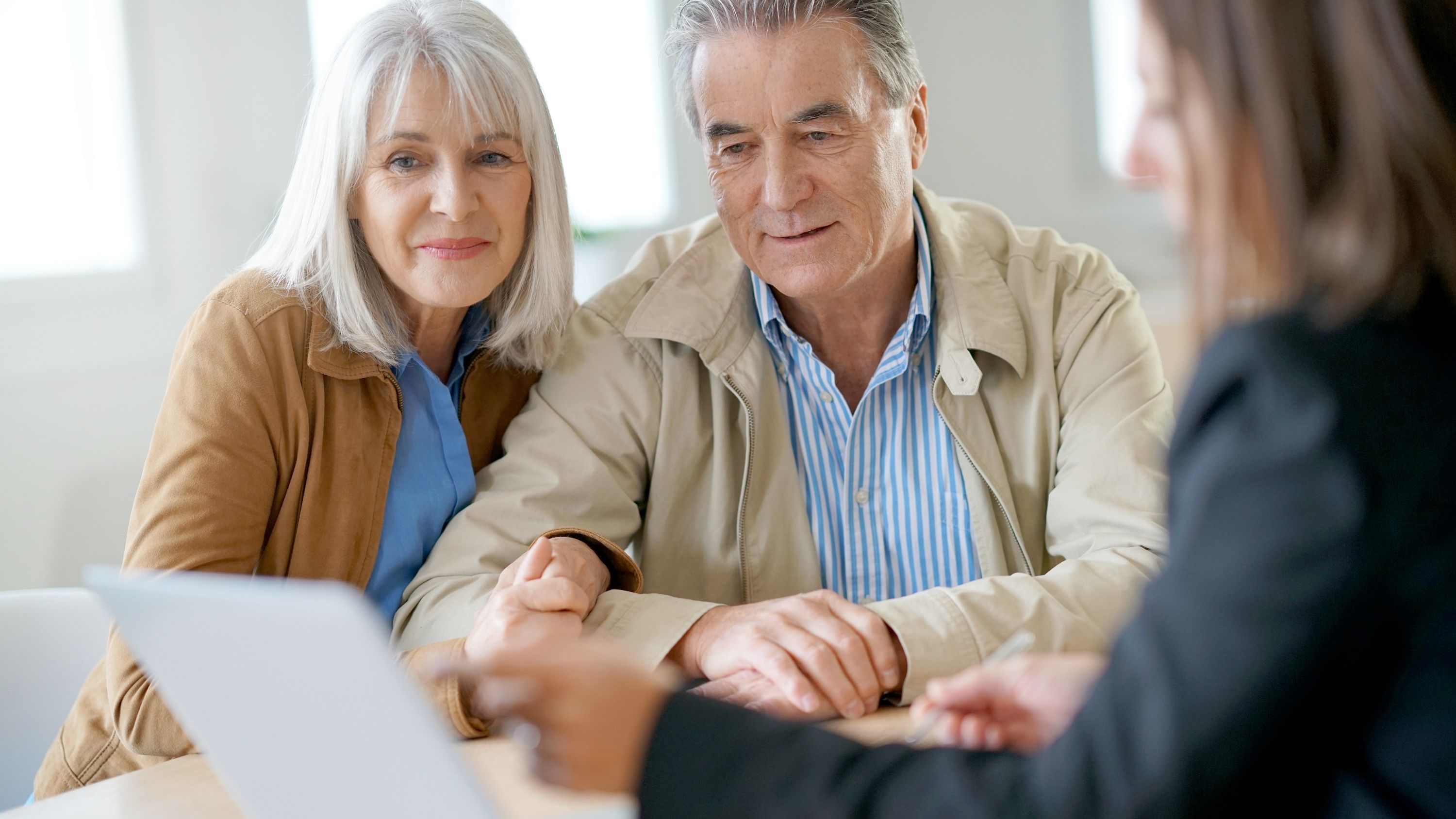 A financial advisor proposes some thoughts to an older couple.