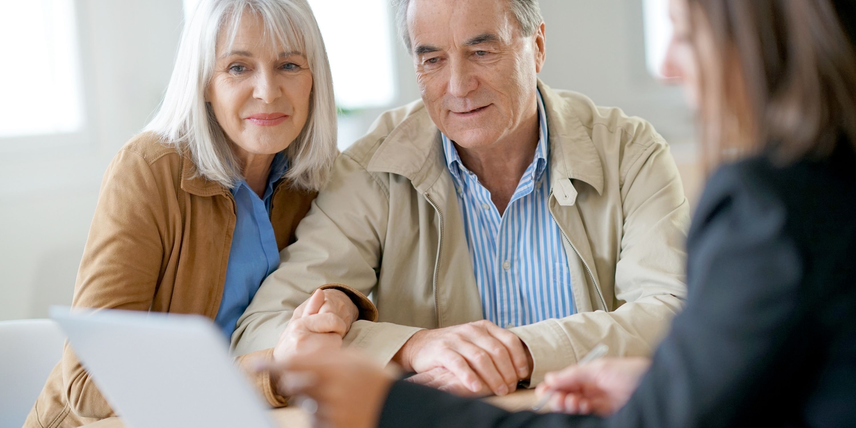 A financial advisor proposes some thoughts to an older couple.