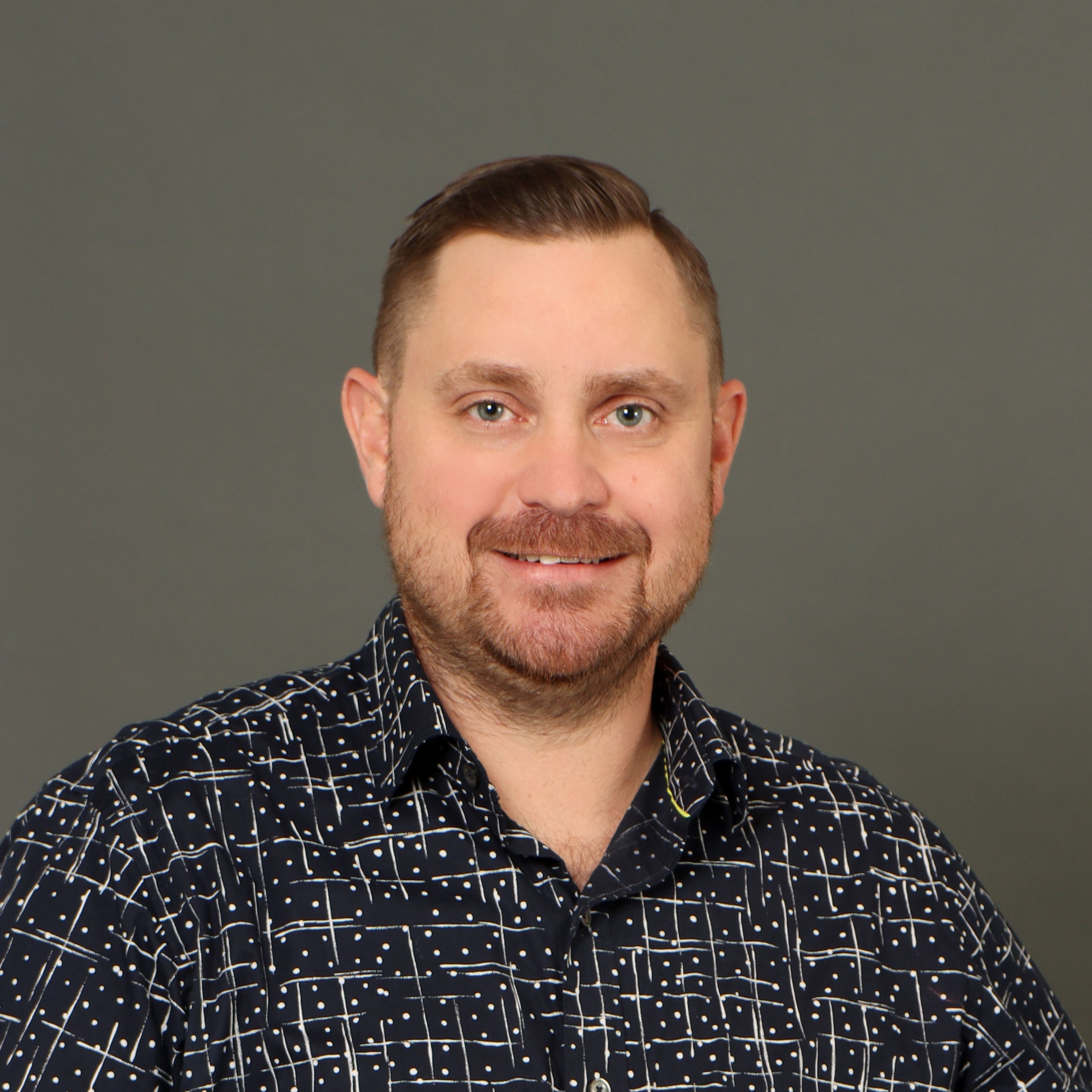 Adam Stepa headshot on a dark background