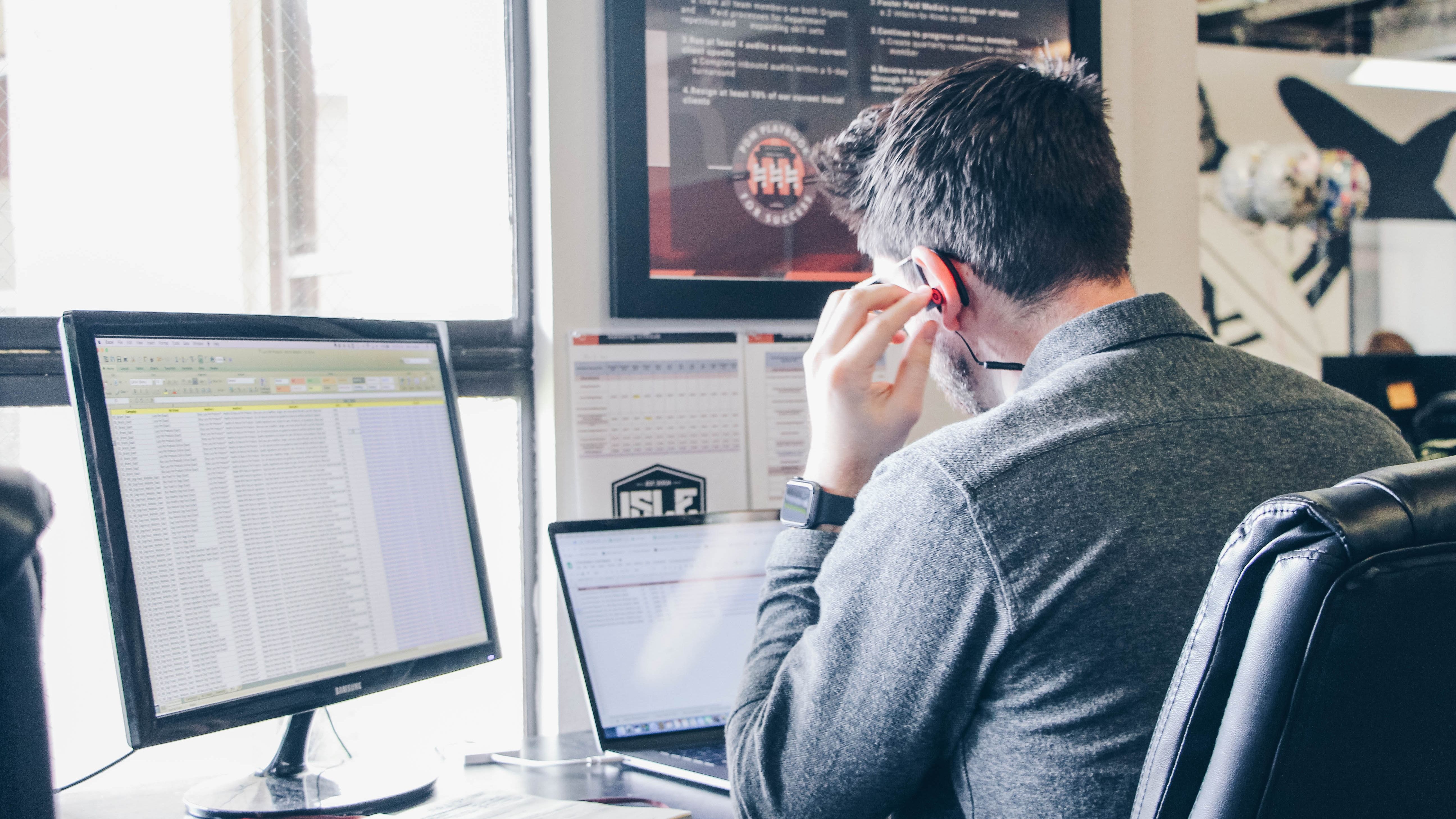 A worker views three separate spreadsheets at once while taking a call at work.