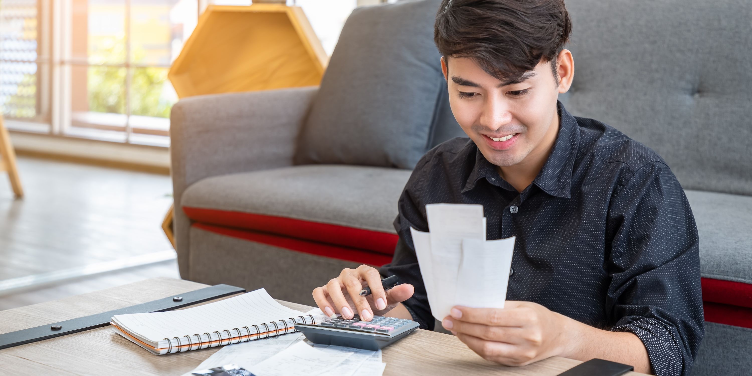 A young person enters values from a receipt into a calculator.