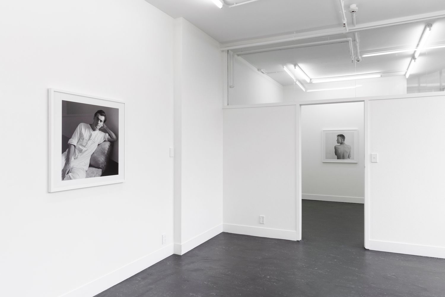 installation image of Adrienne Martyn, Total Control at Envy6011, Wellington, New Zealand. Black and white portraits of men from 1979 - 1988, cheska brown photography