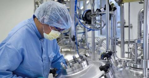 Technician in sterile lab environment working with stainless steel equipment to create silicone tubing.