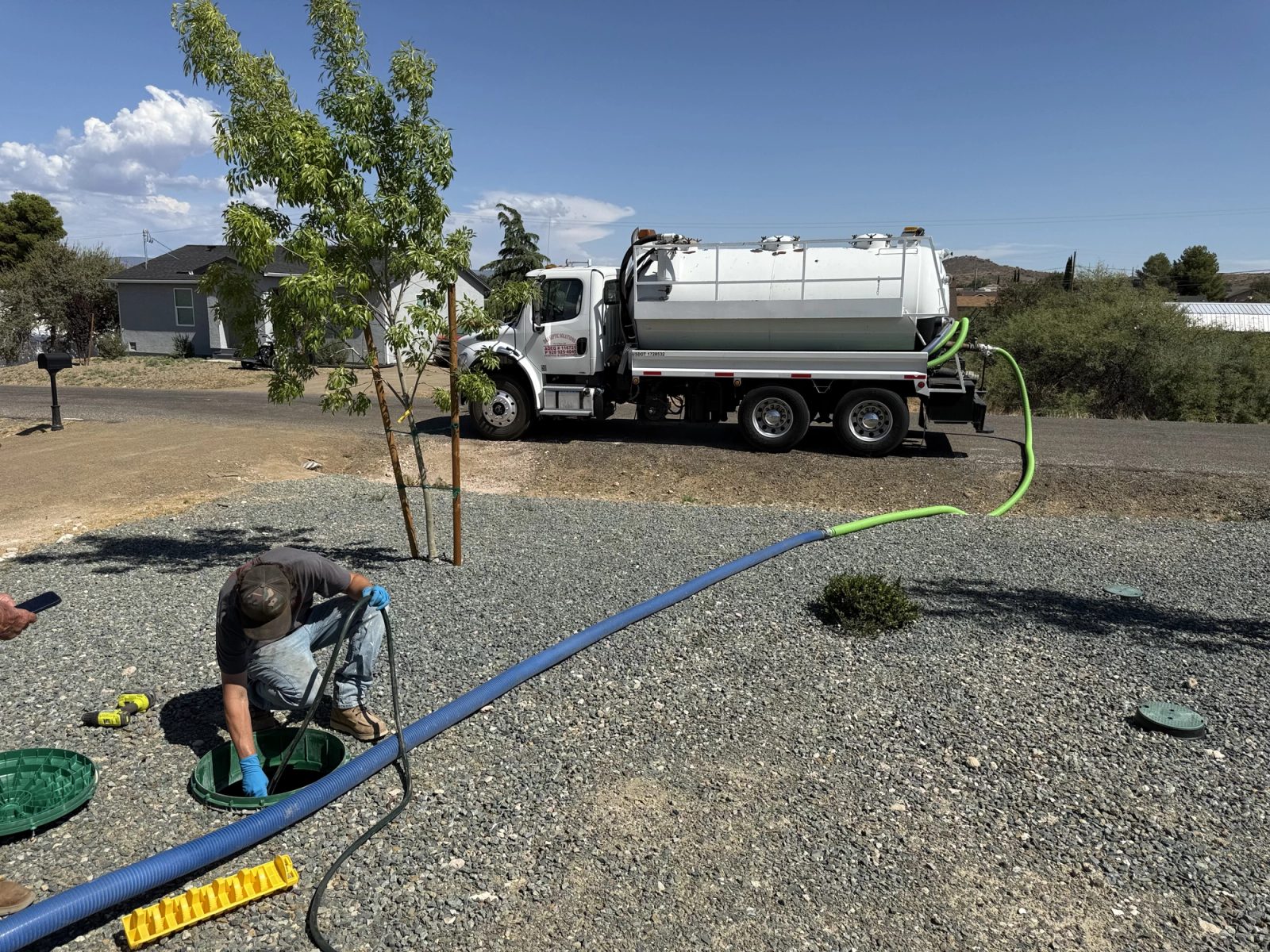 D&S technician pumping a septic tank with the hose connected to the pump truck