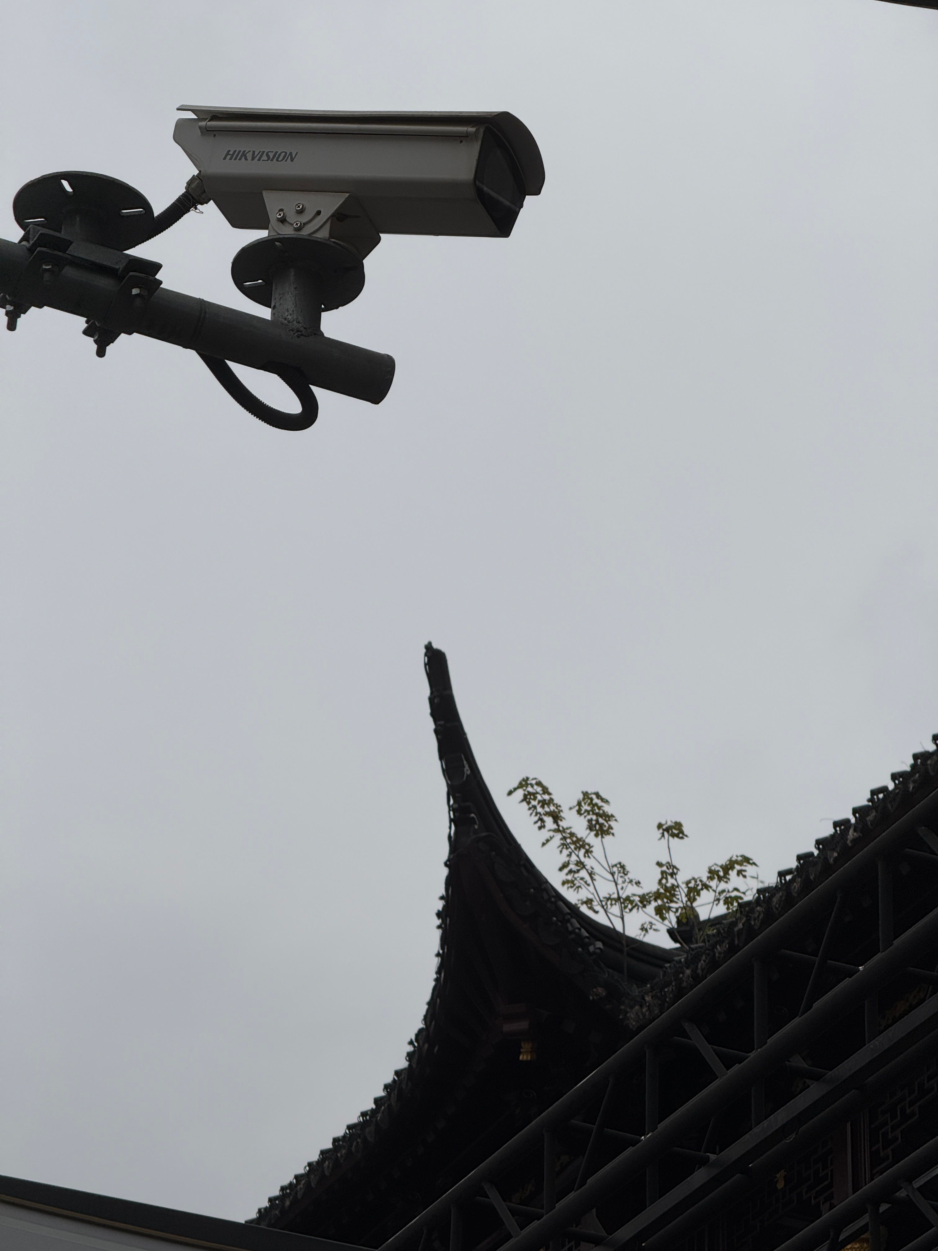 A security camera above the point of a roof