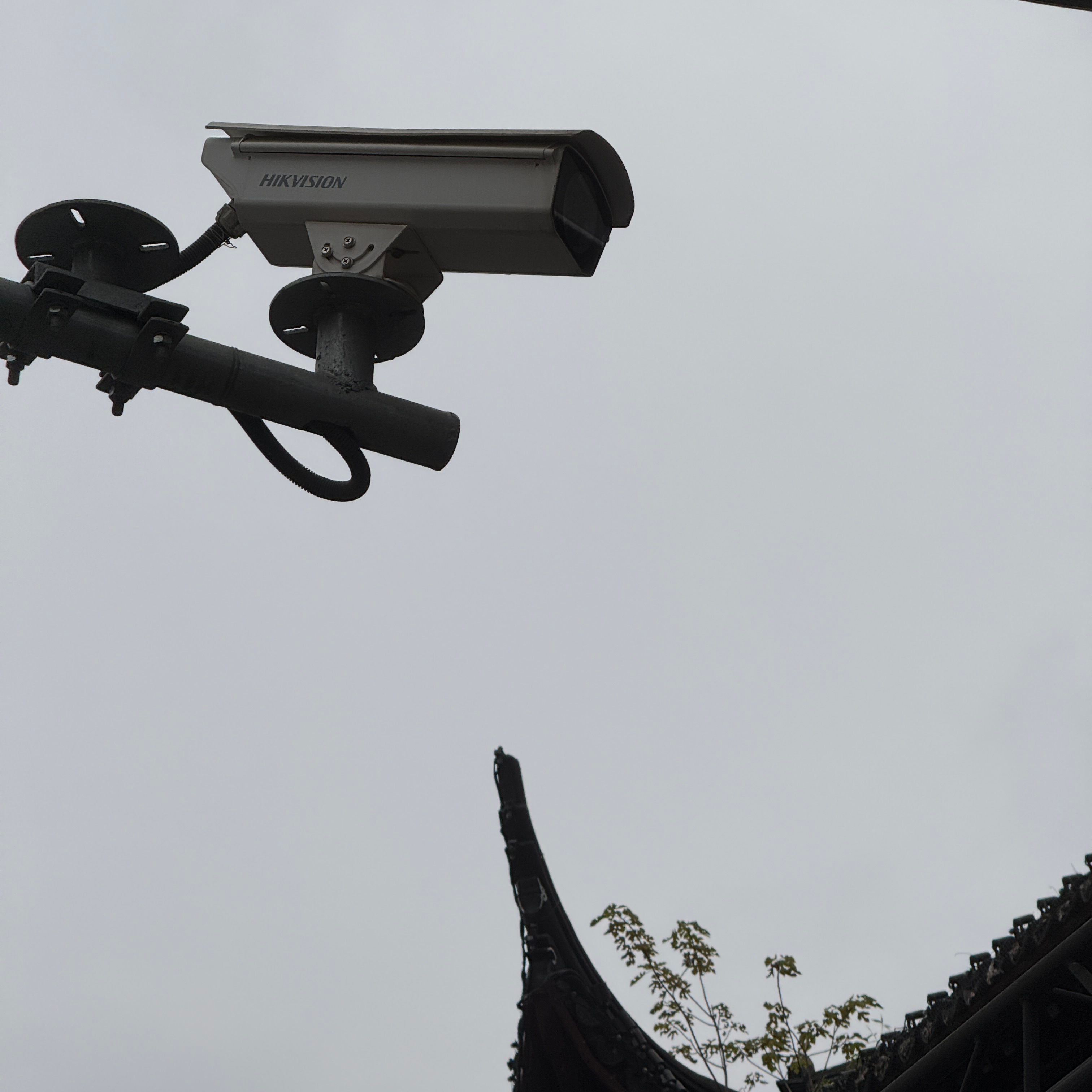 A security camera above the point of a roof