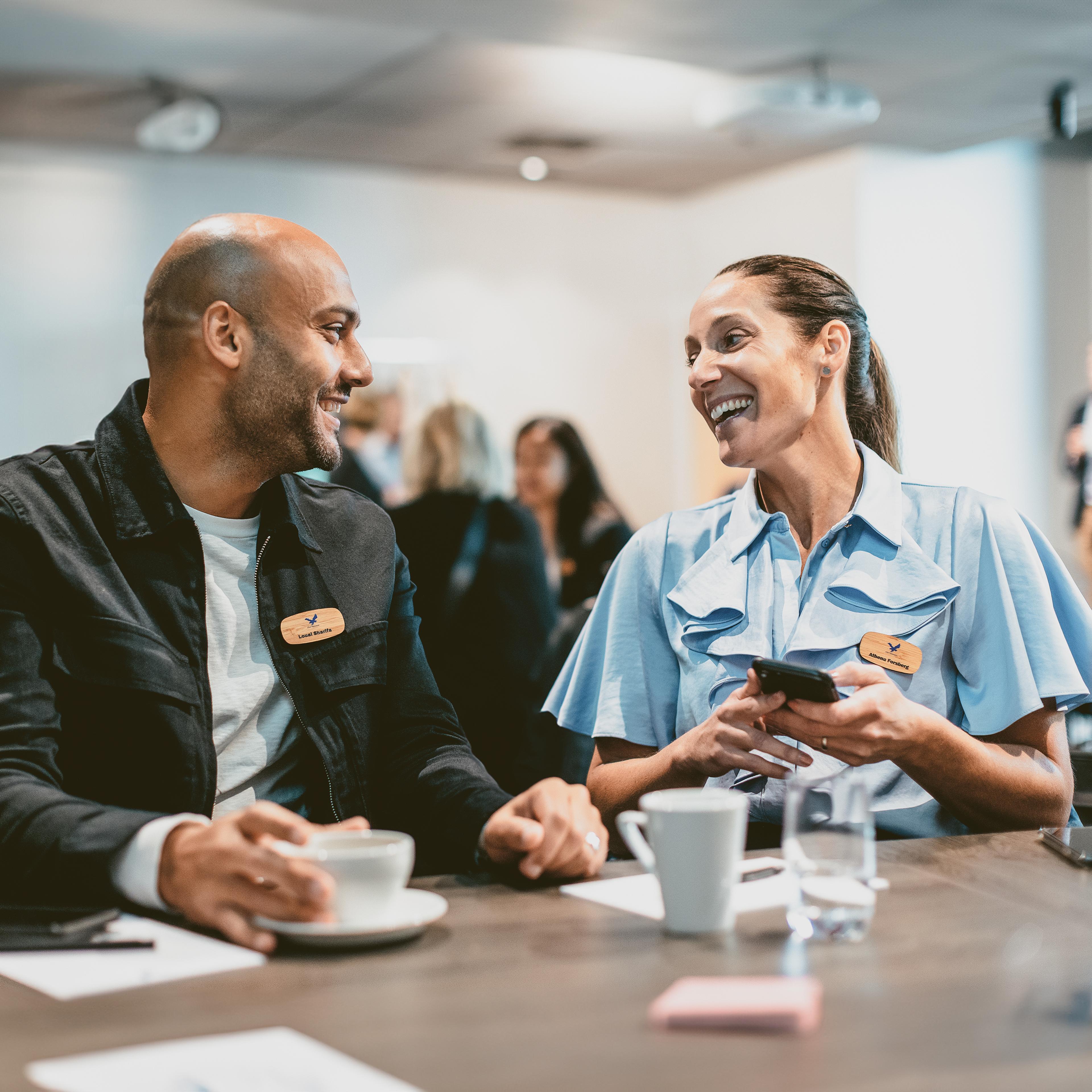 man and woman laughing at a conference