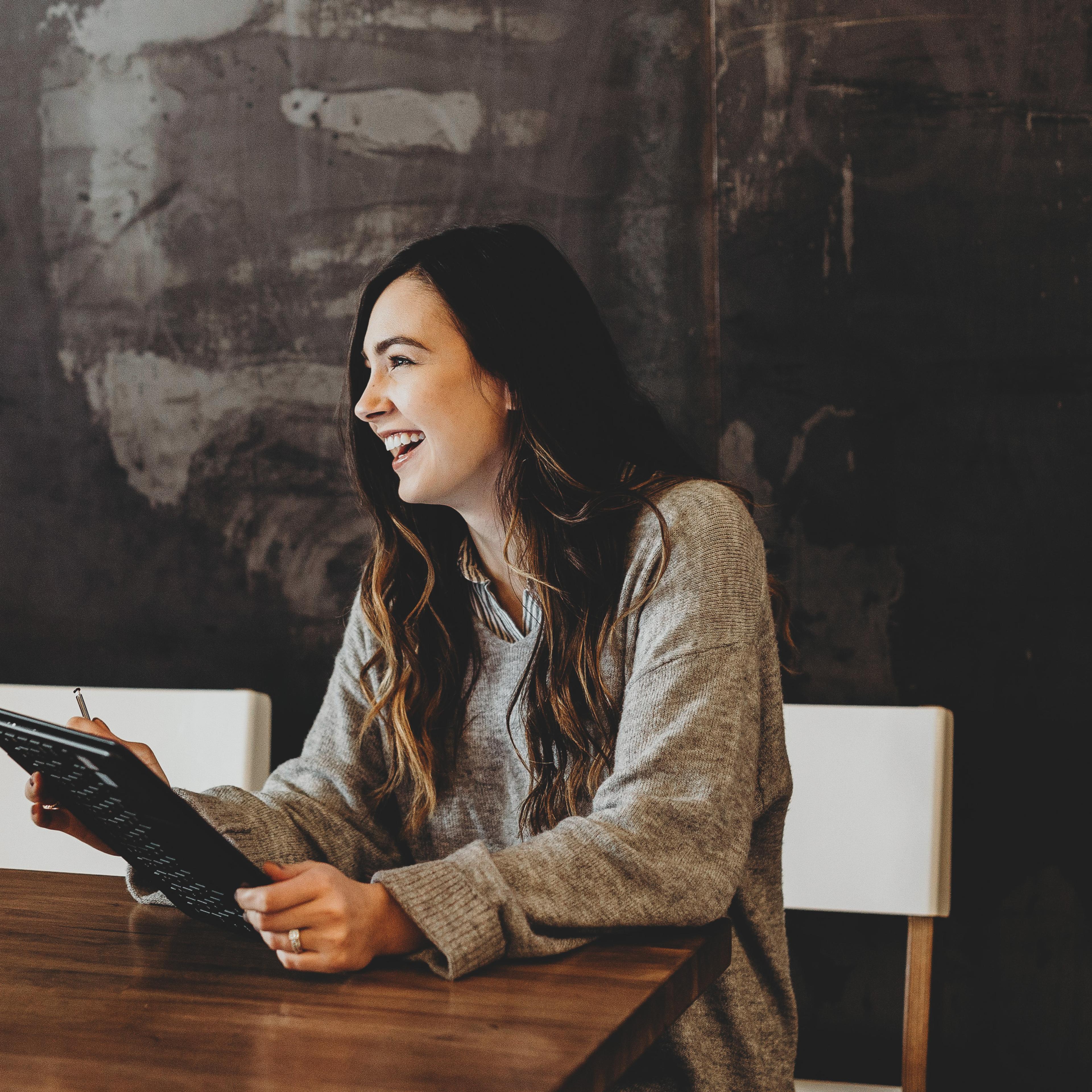 Woman sitting at a table with an ipad