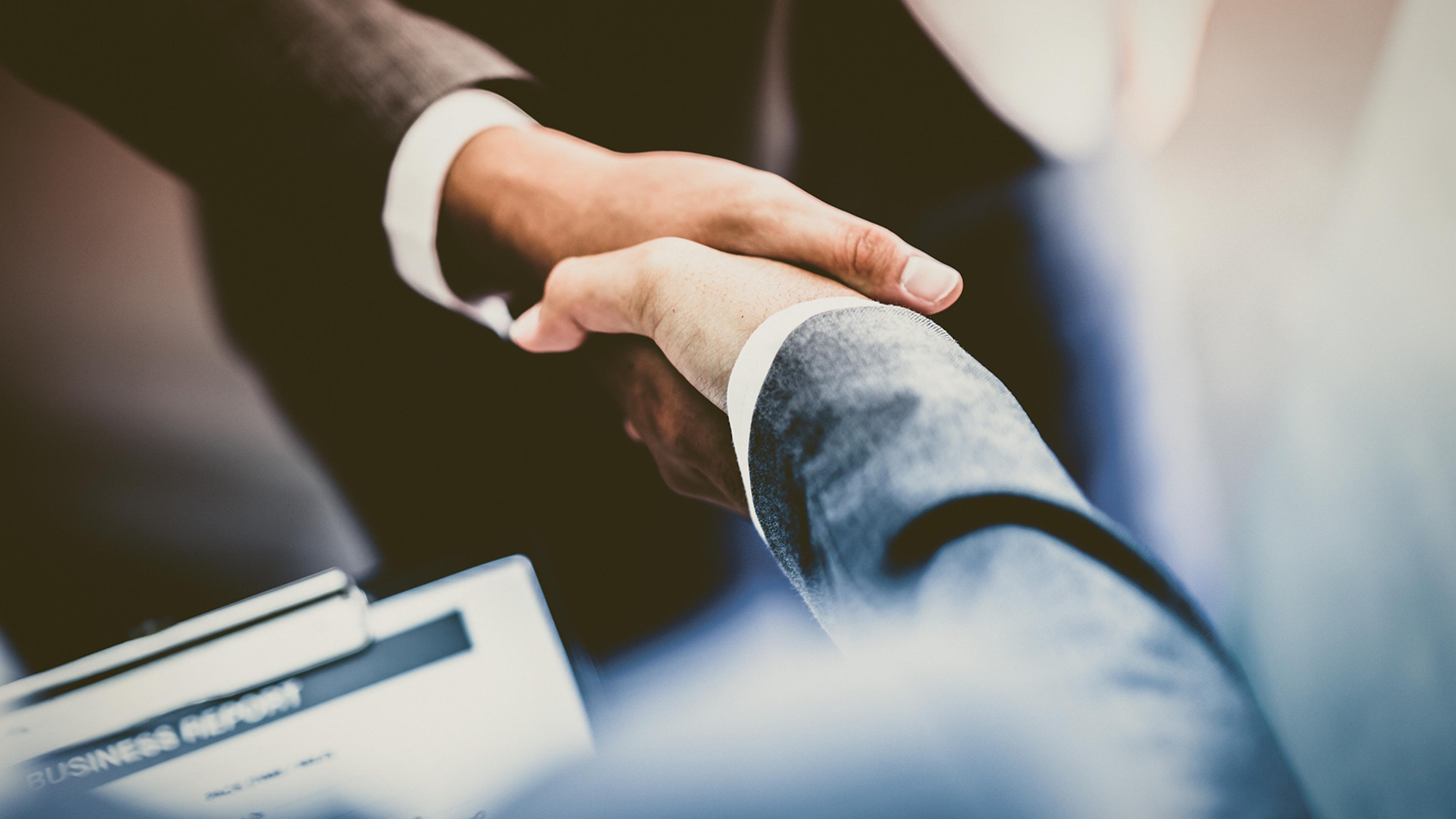 Two persons in suit shaking hands