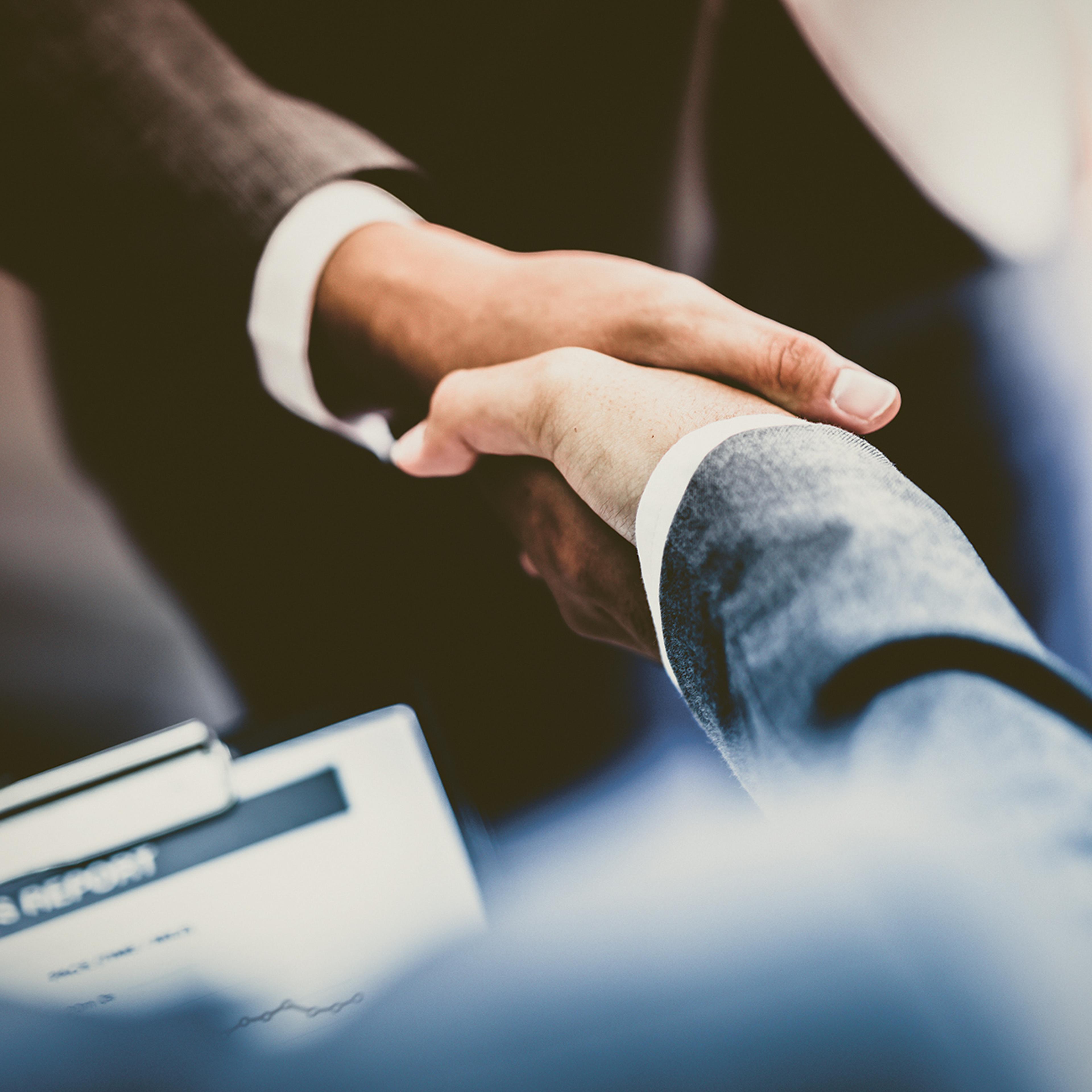 Two persons in suit shaking hands