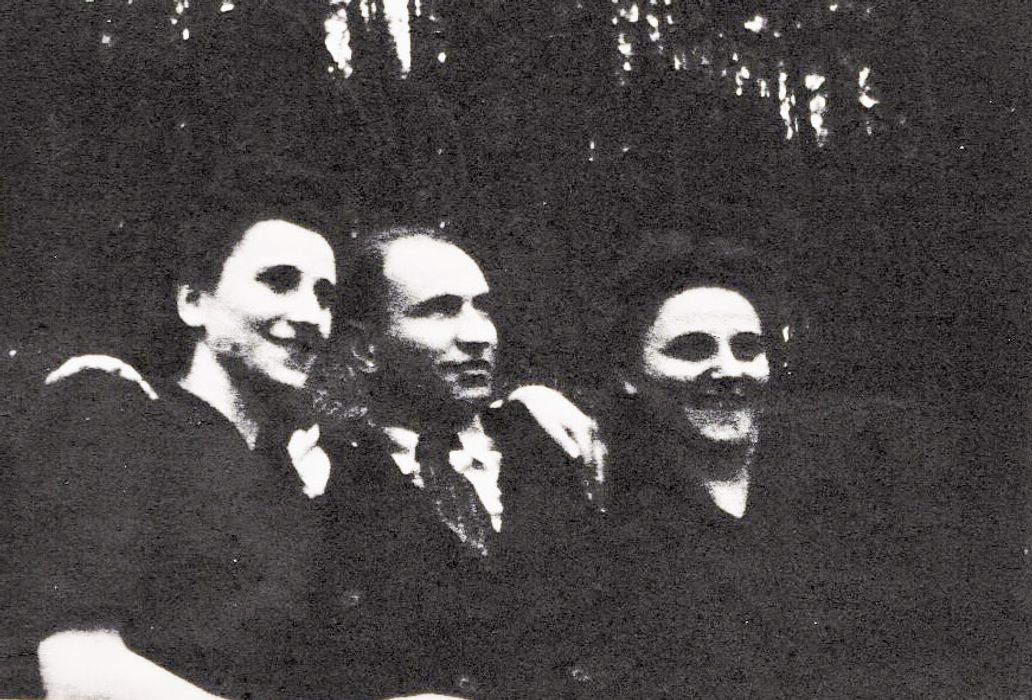 Image of man sitting in between two women, all smiling.