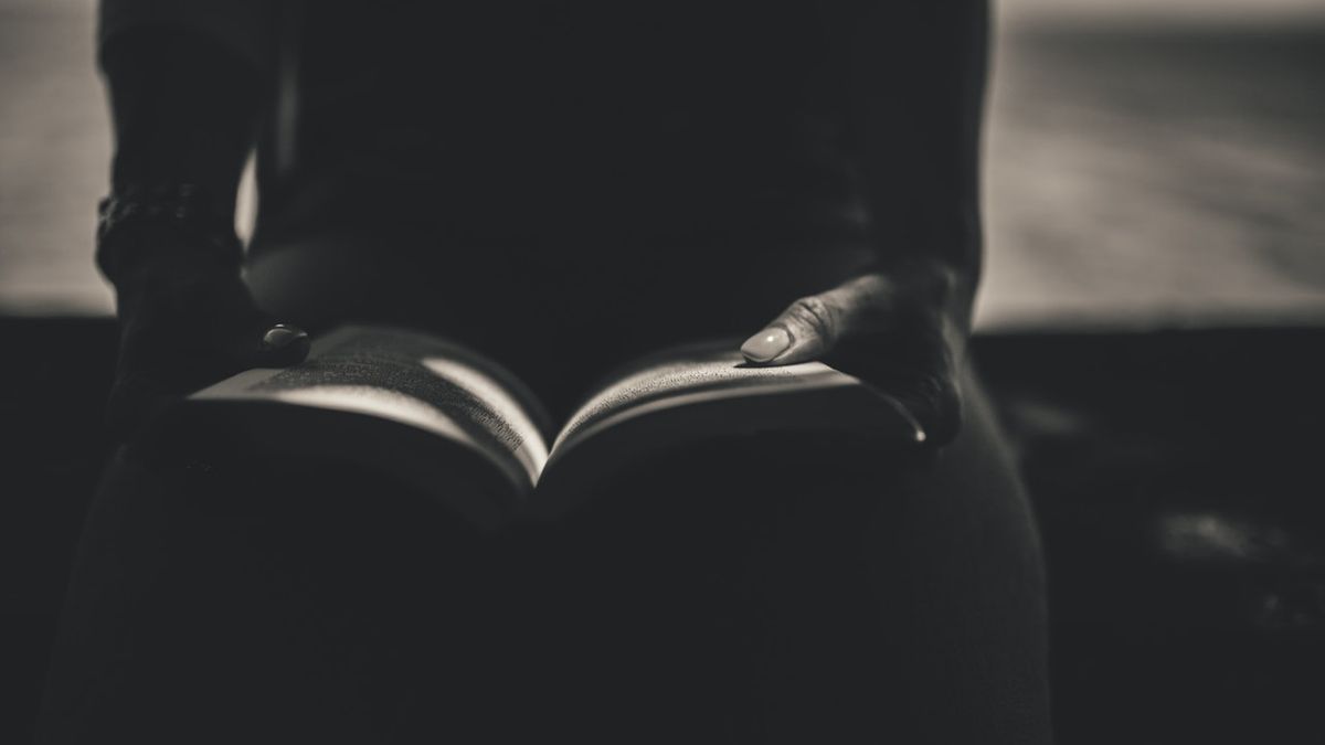 Person Sitting While Open the Book