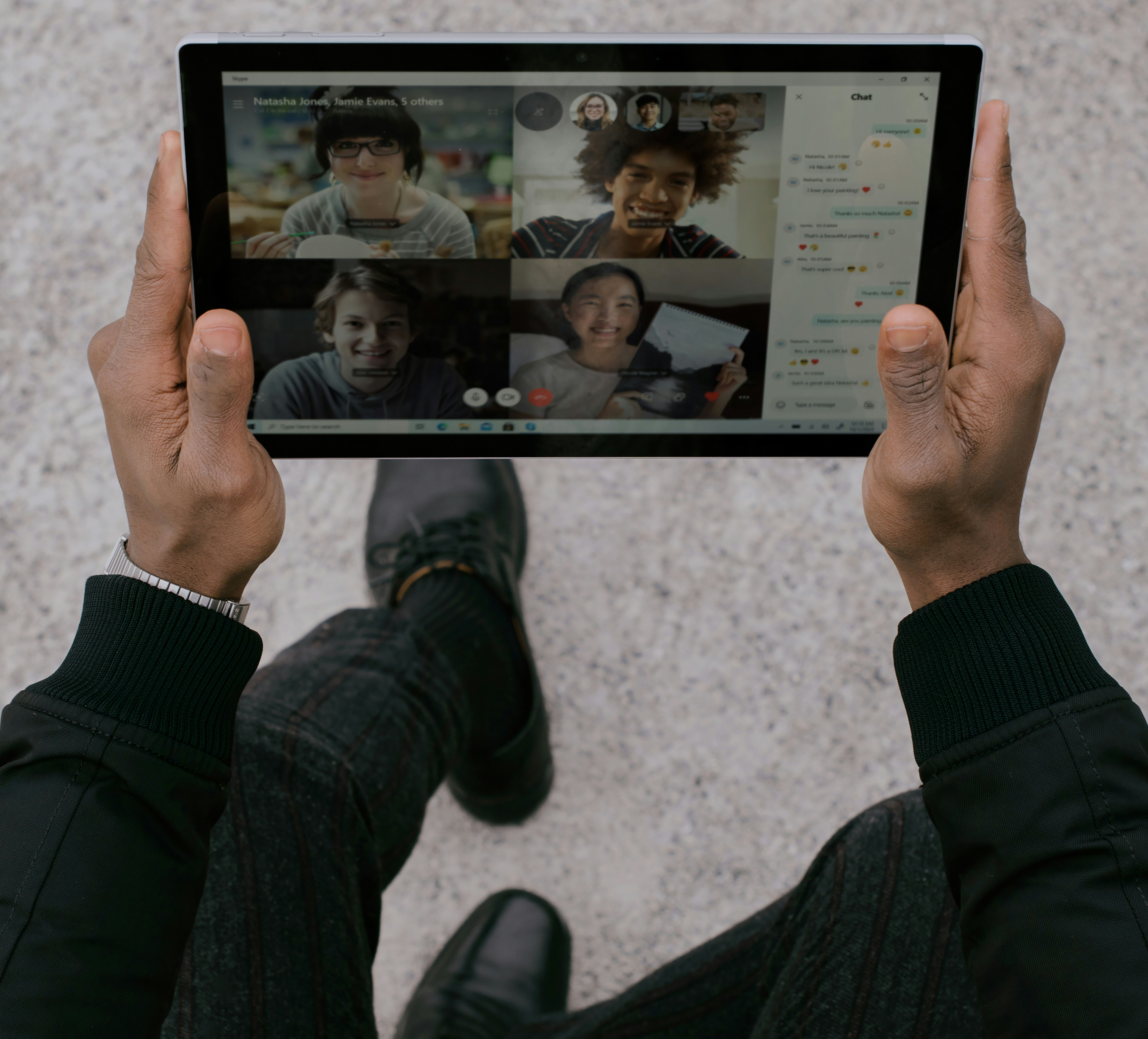 Overhead view of a person holding a tablet during a video call while walking