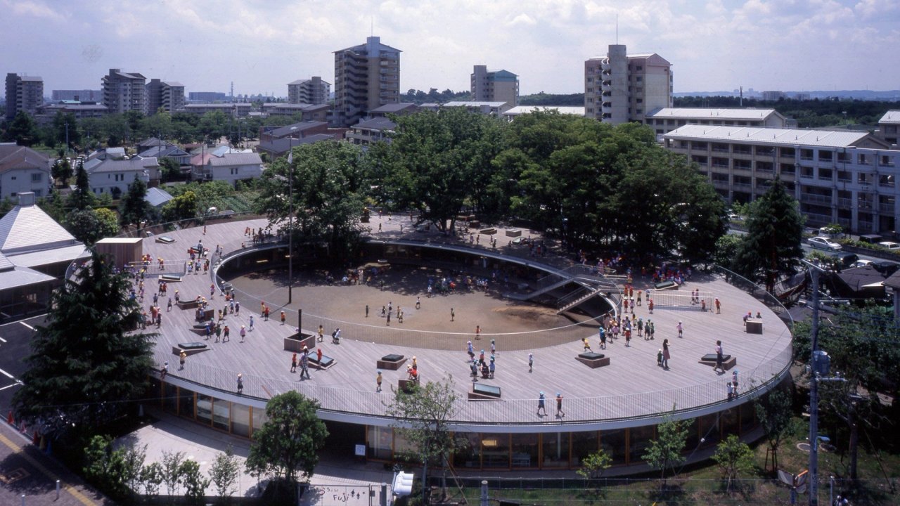 Fuji Kindergarten in Tokyo seen from above: an oval building whose timber roof deck is used as a running track by the children. (taken from google)