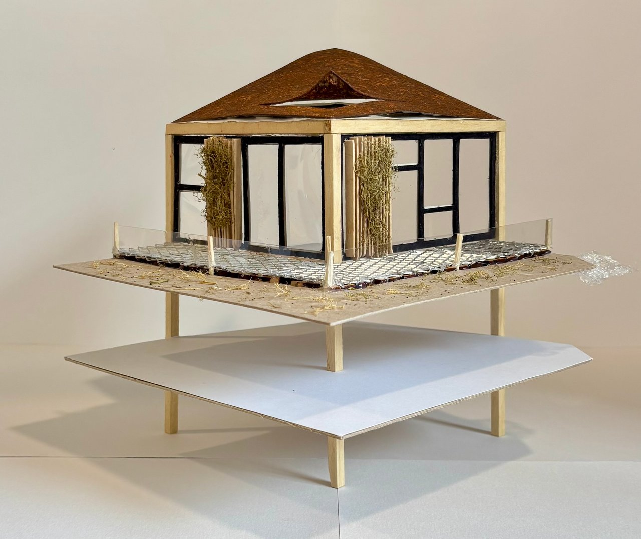Detail model of one campus block, with a corten roof, black window frames, a planted balcony and a lattice canopy below.