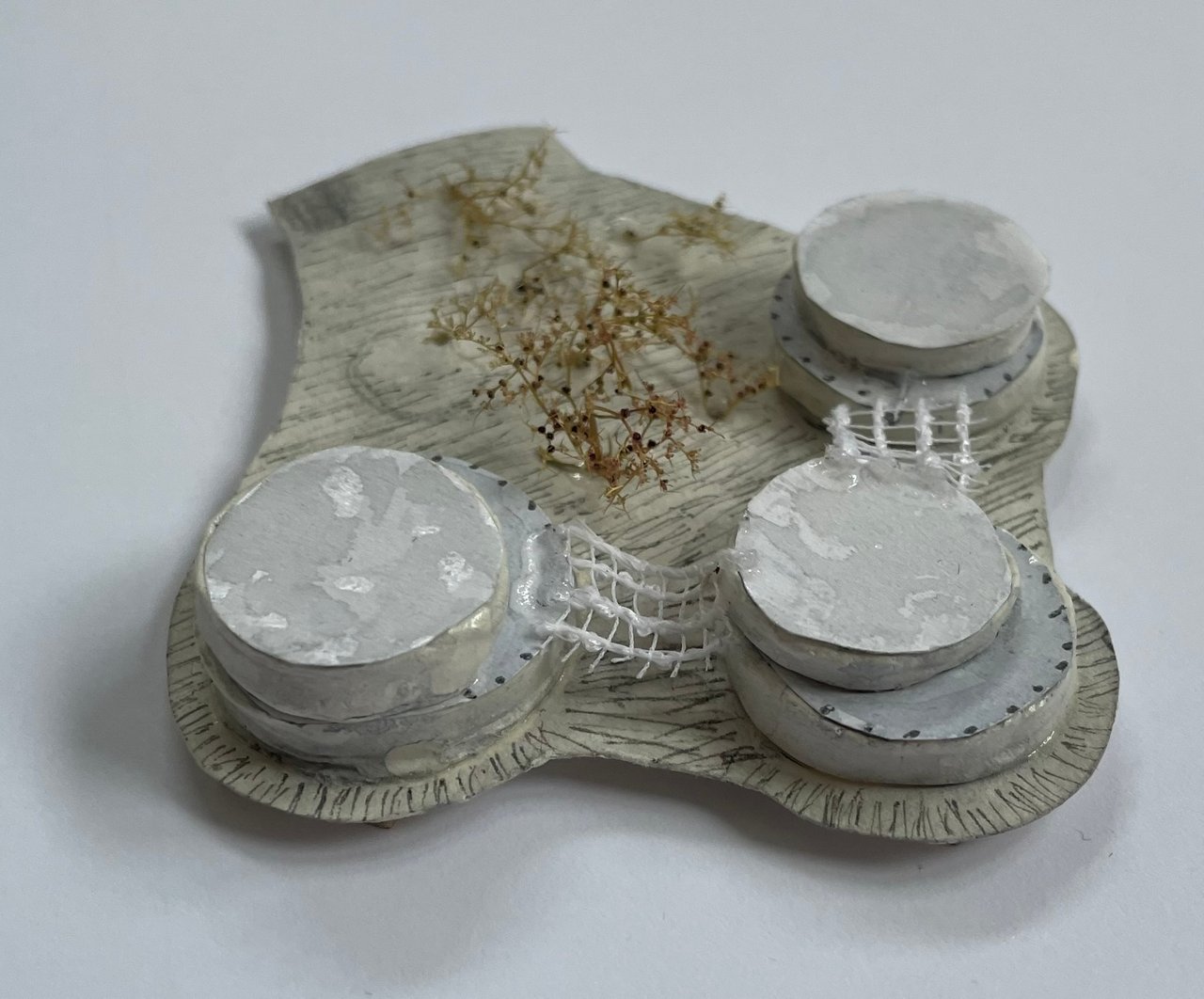 White painted version of the massing model, the base hatched in pencil and netting strung between the blocks.