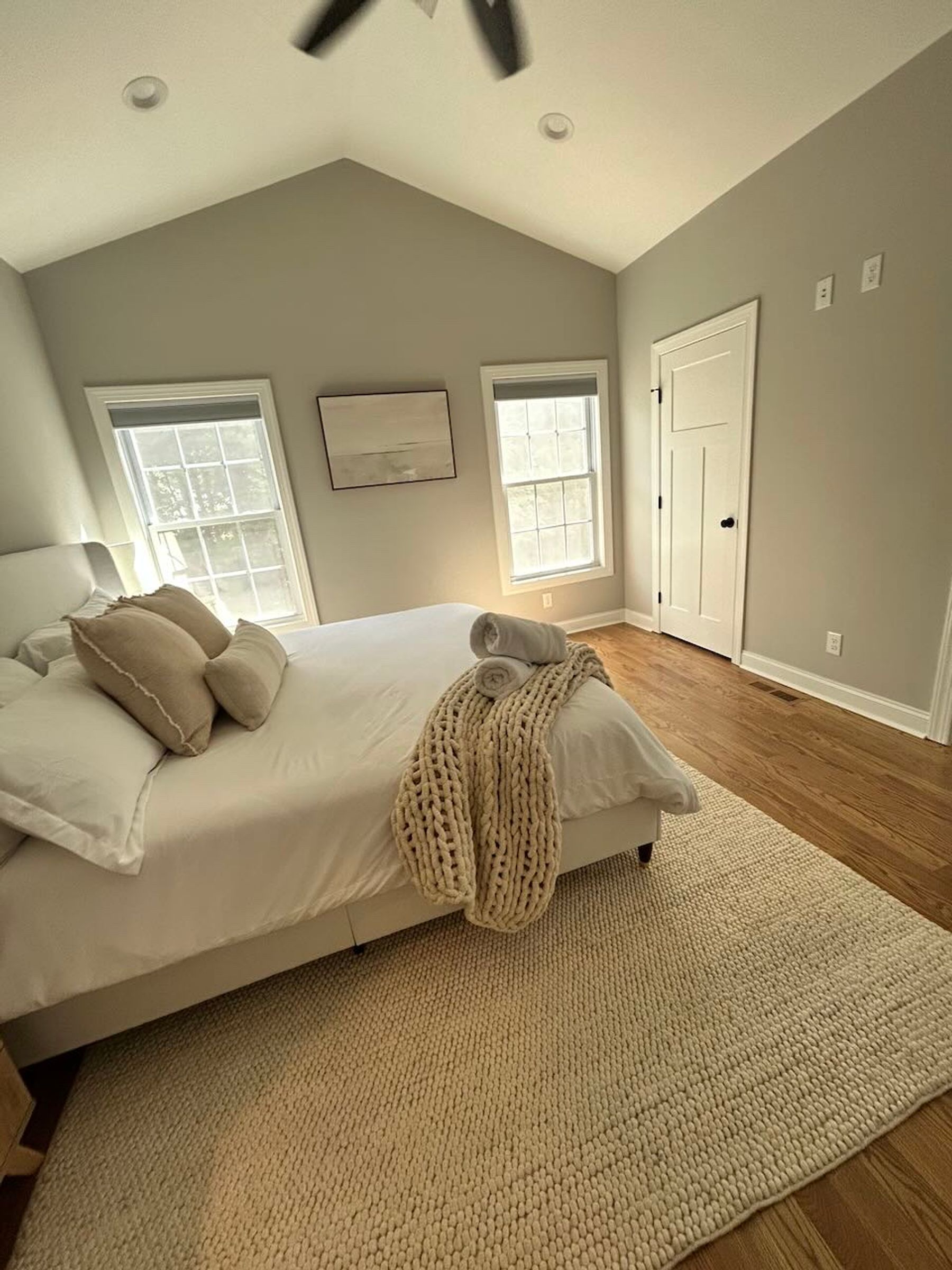Vaulted-ceiling bedroom made up with a knit throw and rolled towels, Forest Virginia